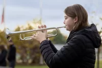 Sophia Cattallani ‘25 of Skaneateles, N.Y., plays taps on Nov. 10, 2023, at Veterans Plaza at the Veterans Day observance. It was the second year in a row Cattallani, whose grandfather was a veteran, played the military’s bugle call at the event. (Phyllis Graber Jensen/Bates College)