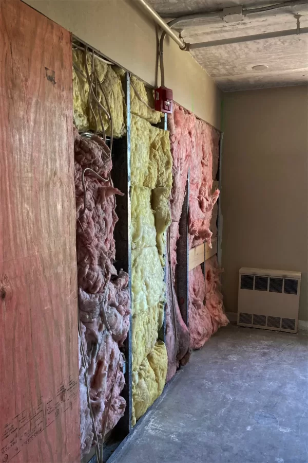 The removal of wallboard during the demolition phase of the 96 Campus Ave. makeover revealed old pastel-colored insulation. (Doug Hubley/Bates College)