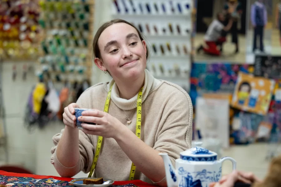 Grace Acton ’24 (in tan sweater) of Harvard, Mass., in costume shop with Carol Farrell, costume shop director, and Bora Luganda ’25 of Kinshasa, Congo, working on costumes for a dance dress rehearsal and enjoying a spot of tea and cake prepared by Farrell. Joined by Adelle Welch ’25 of Livingston, Mont., for tea.