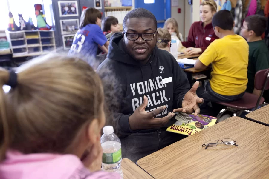 Annual MLK Day Read In at Martel School in 5th grade classroom shows Anthony Phillips '10, Josalynne Cottery '12 (plaid shirt and hair in bun) and Stephanie Sprague '13 (wearing garnet polar fleece top).