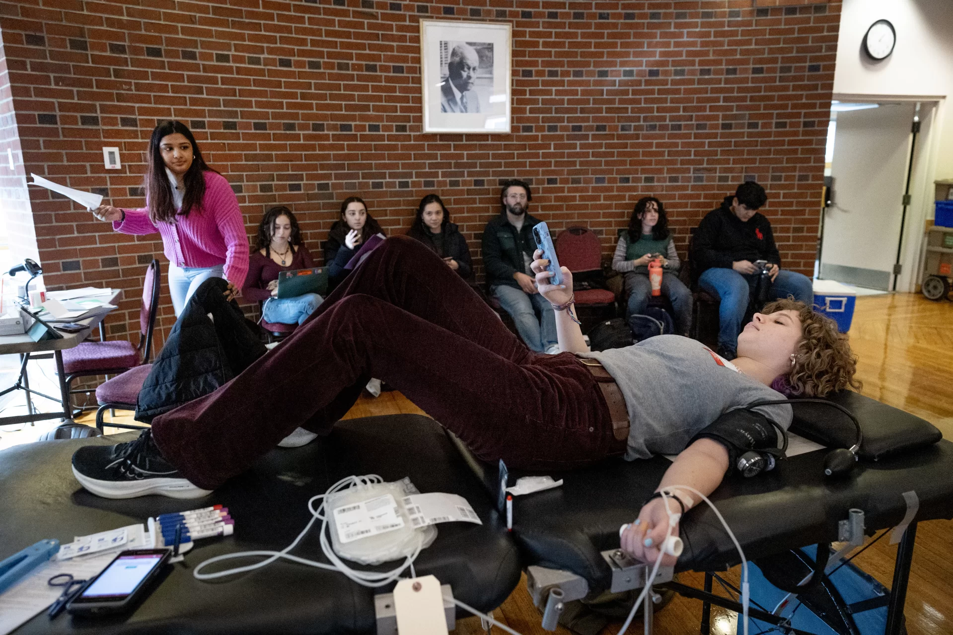 “After the mass tragedy in October, I wanted to help out by donating blood, but every donation spot to donate blood was filled for weeks. I contacted the American Red Cross to see if Bates could help out in any way, and here we are with our first blood drive on campus in four years. This is the start of many more drives!”

— Sivani Arvapalli ’26 (in pink sweater) of South Windsor, Conn., explaining why she collaborated with the Northern New England Region of the American Red Cross to hold today’s blood drive in the Benjamin Mays Center, the first collection on the Bates campus since 2019. Moving forward, the college and American Red Cross are planning to host four drives per year.

The American Red Cross is experiencing an emergency blood shortage as the nation faces the lowest number of people giving blood in 20 years. The Red Cross blood supply has fallen to critically low levels across the country, and blood and platelet donors are urged to make a donation appointment to help alleviate the shortage and help ensure lifesaving medical procedures are not put on hold. Snow, ice, and extreme temperatures have contributed to the shortage by making it harder to move blood products across the Red Cross network.

“It’s worth a couple of hours of your day to do this!” said Jamie Shelton ‘27 of Zurich, Switzerland.

Mya Laliberte ’25 of Rangeley, Maine, in patterned sweater. They’re to help her friend Sivan’s efforts. She donated right after Oct. 25, 2024 and wanted to do it again.

Jamie Shelton ’27 is in gray sweater. “It’s important — and — convenient.”

Aislinn Carty ’24 of Mountville. Pa, with long hair and earrings. “I’ve never done it before. It’s a great opportunity.”