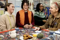 As she's done for years, Carol Farrell (right), supervisor of the Bates costume shop, gathers her student workers for afternoon tea on Feb. 13, 2024. From left, Bora Luganda ’25 of Kinshasa in the Democratic Republic of the Congo, Grace Acton, and Adelle Welch ’25 of Livingston, Mont. (Phyllis Graber Jensen/Bates College)