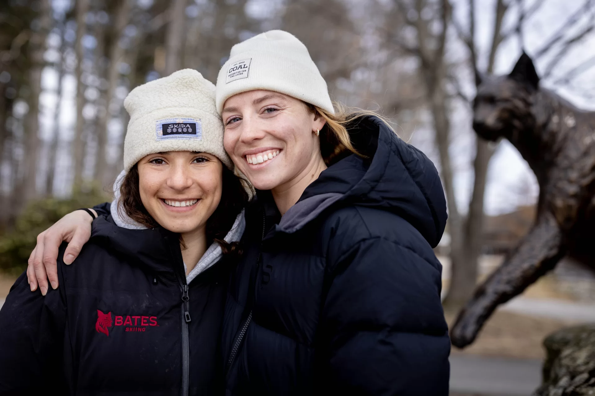 Alpine skier Juliette Holder ’27 (left) of Stowe, Vt., and and Nordic skier Olivia Cuneo ’24 of St. George, Vt., posing in front of the Bobcat statue adjacent to Merrill Gymnasium,have qualified for and are on their way to the NCAA
 Championships in Steamboat Springs, Colo.