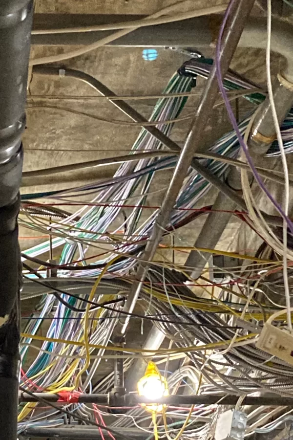 Cables for data, electrical service, and other uses form a tangle near the ceiling on the first story of 96 Campus Ave. (Doug Hubley/Bates College)