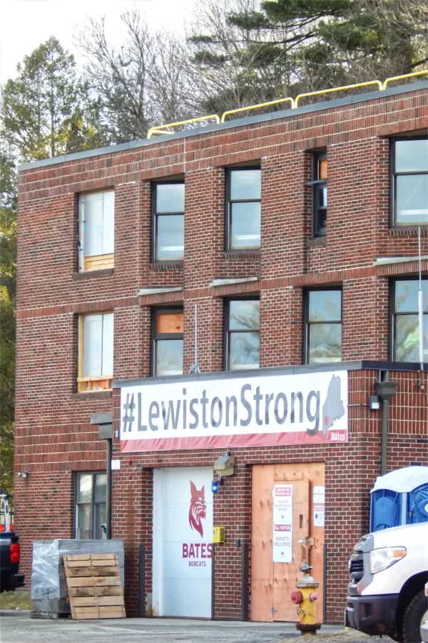 Shown is the northwestern corner of 96 Campus Ave., including the loading bay that will become the building’s main entrance. Among other upgrades, glass will go where the plywood is now, and a person door (to use the technical term) will replace the overhead door. The college hung the “#LewistonStrong” banner as a morale boost following the shootings in October 2023. (Doug Hubley/Bates College)