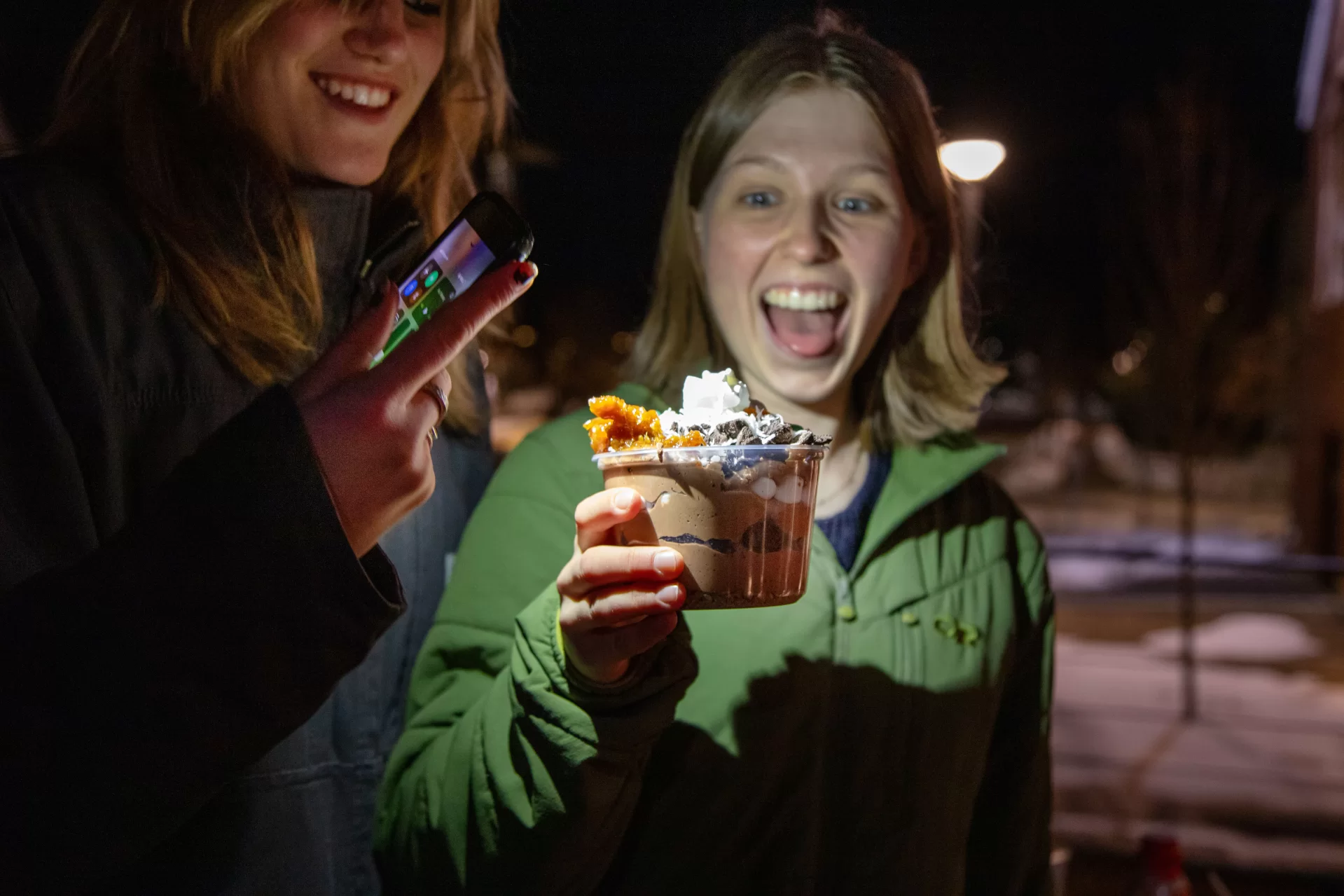 Members of the Bates Outing Club gathered for a Iron Chef-like grill competition, all attempting to make the best dessert in just thirty minutes. Lilly Miller '25 and Gwendolyn Anderson '27 show off their group's dessert, made from ingredients like homemade chocolate mousse and toffee meant to mimic the layers of the Earth.