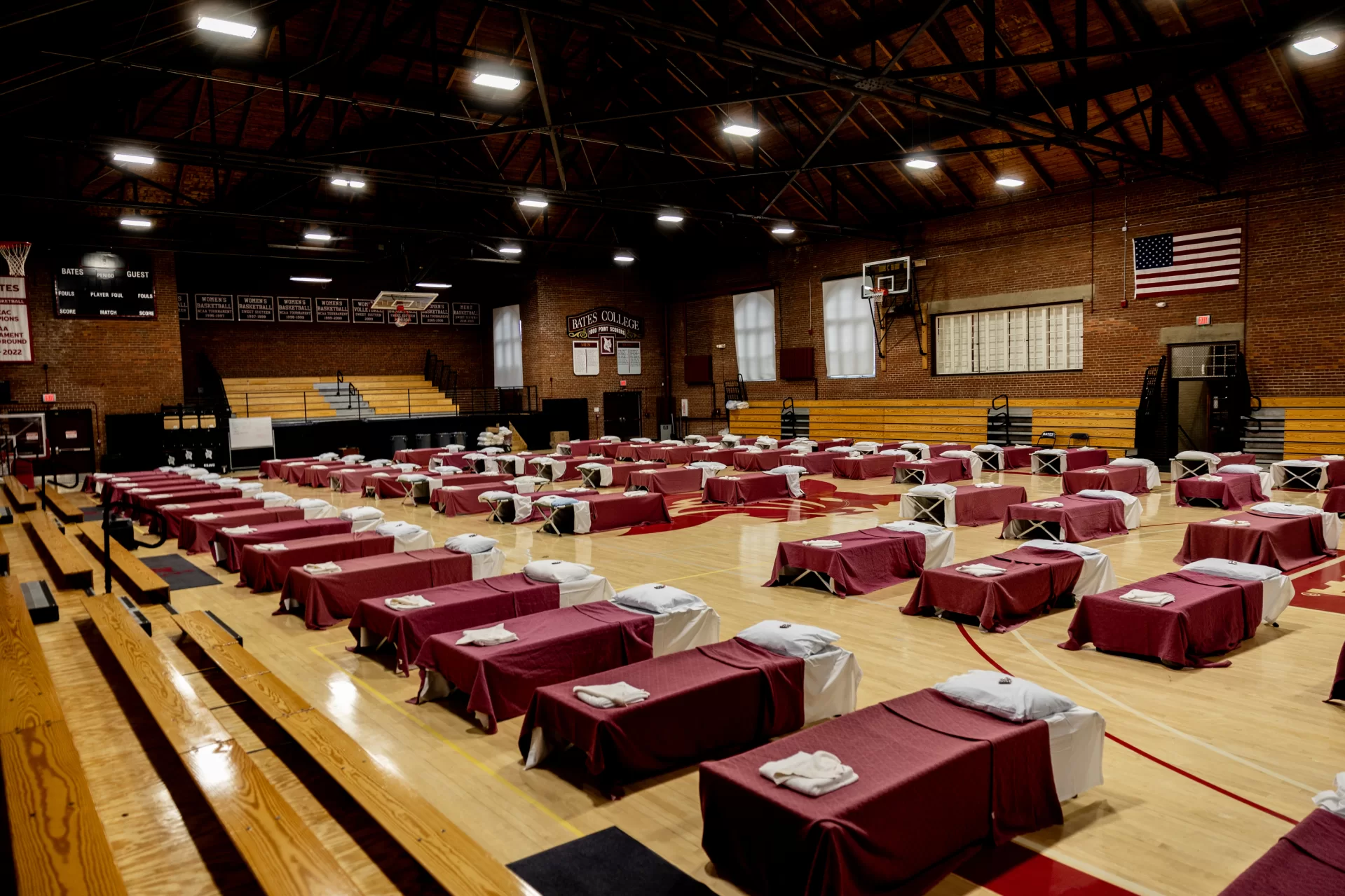 With eclipse tourism making local lodging scarce, Bates quickly opened Alumni Gym and Commons on Friday to help house and feed some of the 1,000 utility crews who’ve traveled to Maine to support power restoration efforts in the wake of the major snowstorm that cut power to hundreds of thousands of Mainers. By Friday afternoon, 75 beds (provided by the Maine Emergency Management Agency) were all made up in the gym — each with a Bates chocolate on the pillow. The Bates chocolates are a greeting, said Christine Schwartz, associate vice president for dining, conferences, and campus events. “They’re a symbol of welcome and thank you from Bates for the work that is being done.” The work to open Bates to the crews was also supported by Bates Facility Services.
