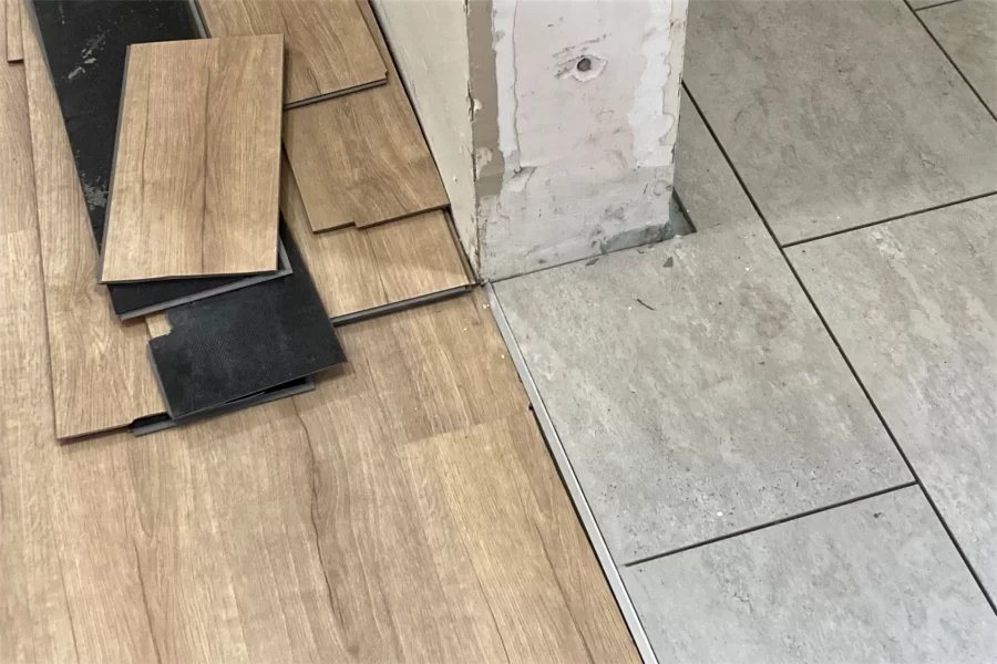 The trim strip separates two styles of new flooring in 96 Campus Avenue: tiling for a bathroom, at right, and a wood-grain product  for general use (both installed and awaiting installation) at left. (Doug Hubley/Bates College)