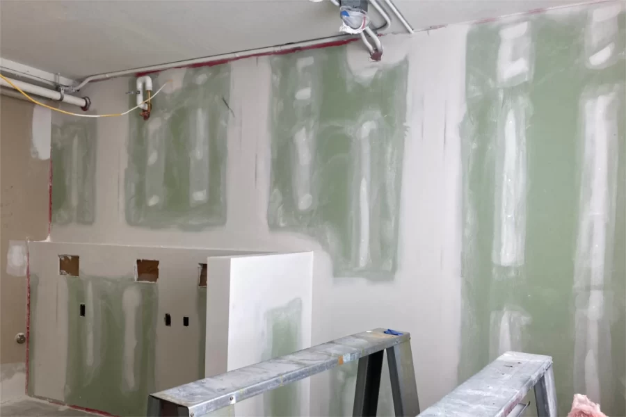 Wallboard is in place in the student laundry room at 96 Campus Avenue, located on the second floor. The cutoiuts at lower left are for plumbing and electrical fittings. (Doug Hubley/Bates College)