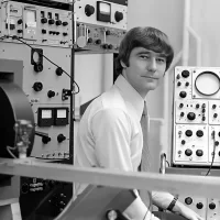 scientists sitting before physics equipment