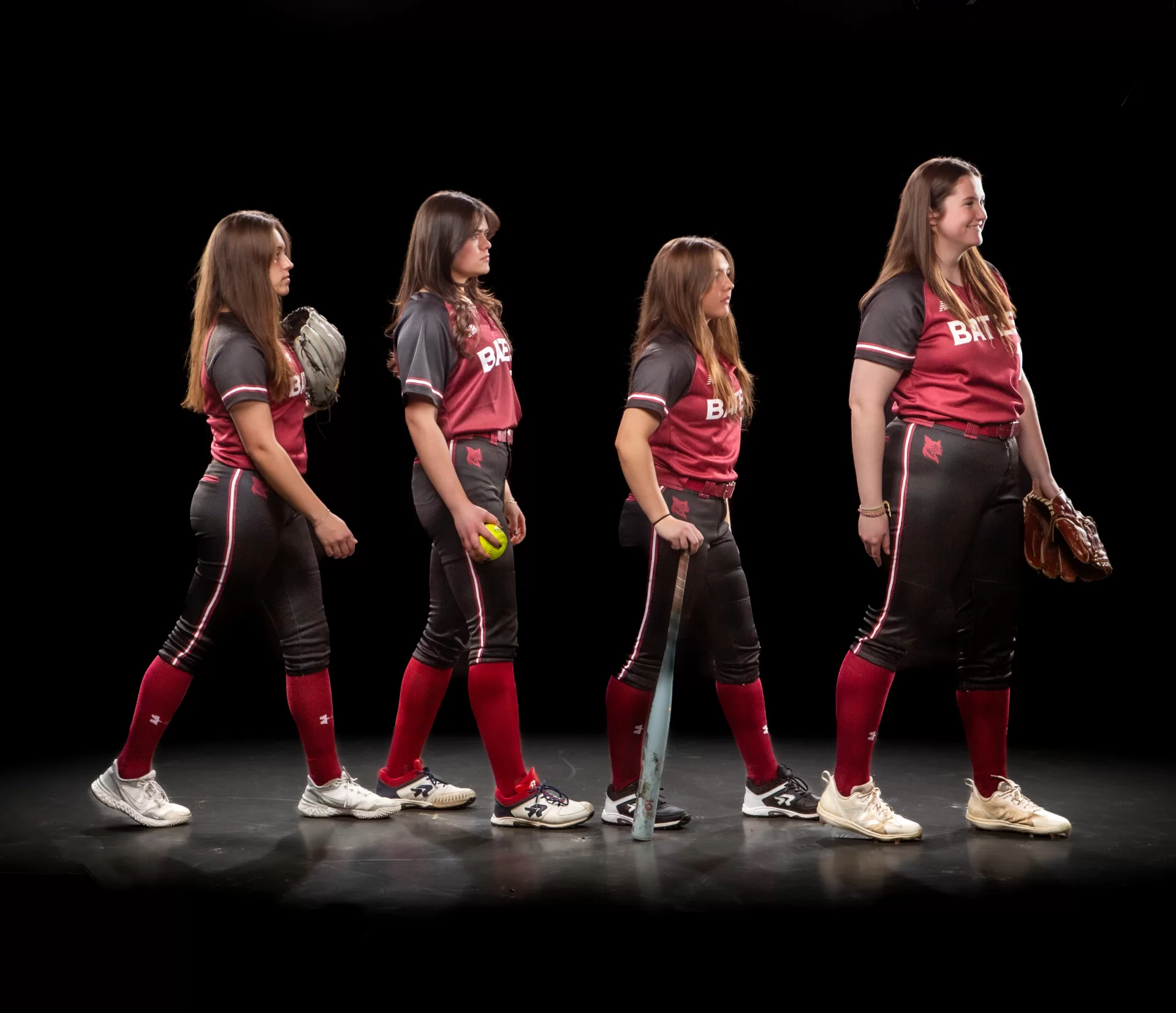 four softball players recreating the cover of Abbey Road