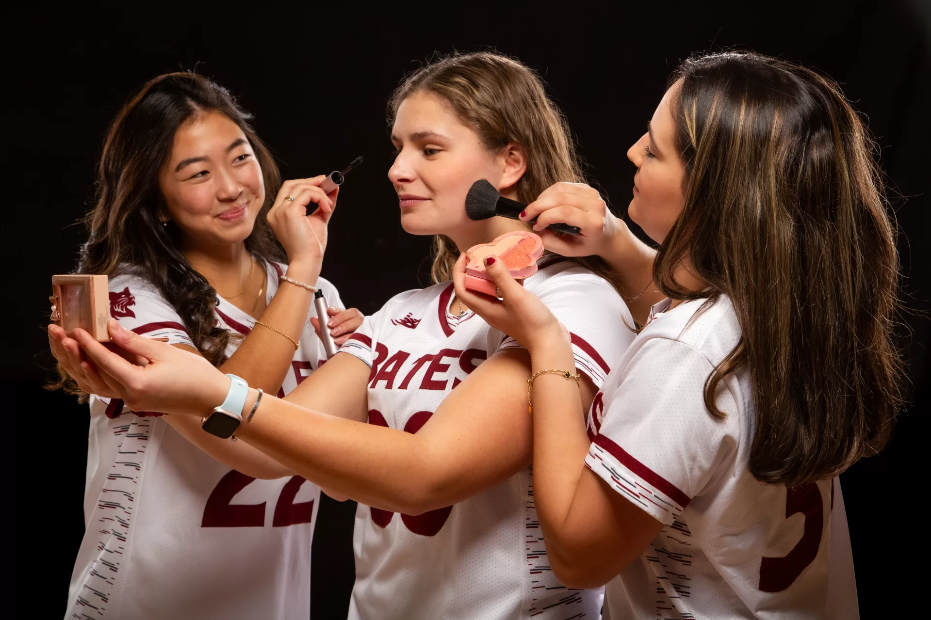 three lacross players pretending to apply makeup.