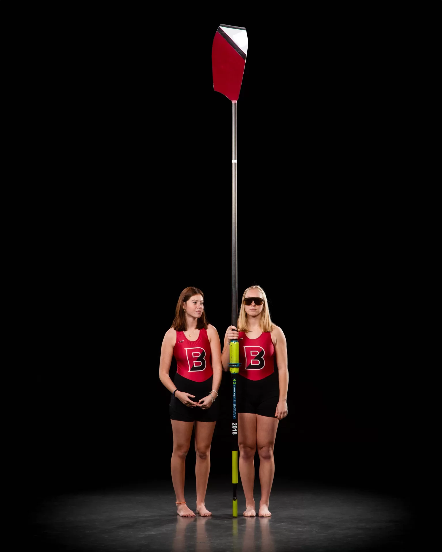 Two rowers holding a long oar