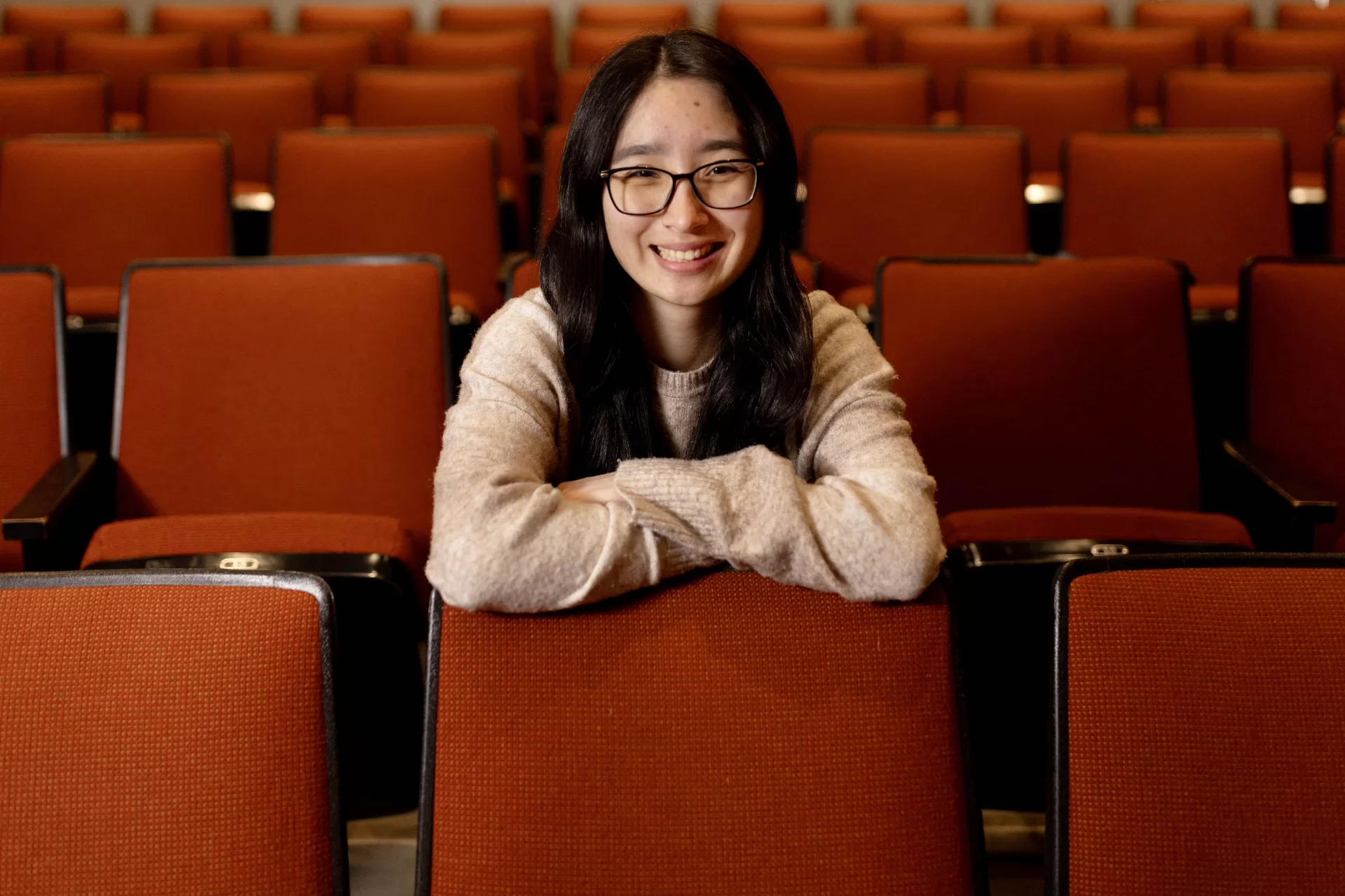 person posing in a theater seats.