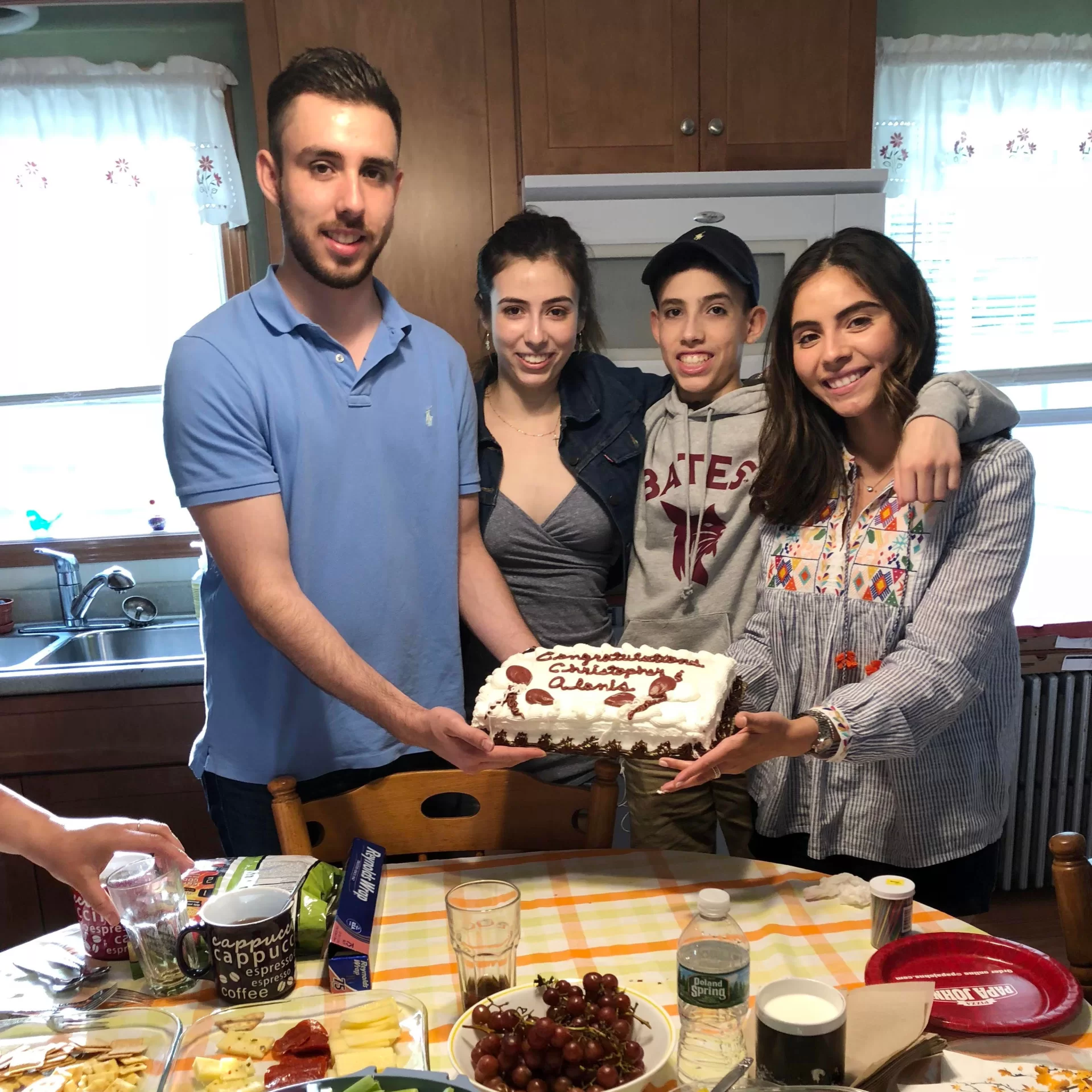 four siblings hold a cake