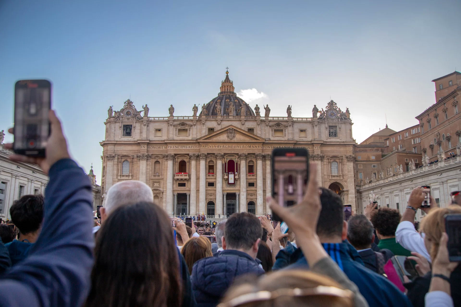 Visitors to St. Peter's Square capture images of Cardinal Robert Prevost's first speech as Pope Leo XIV, on the balcony of St. Peter's Basilica, on May 8, 2025.
