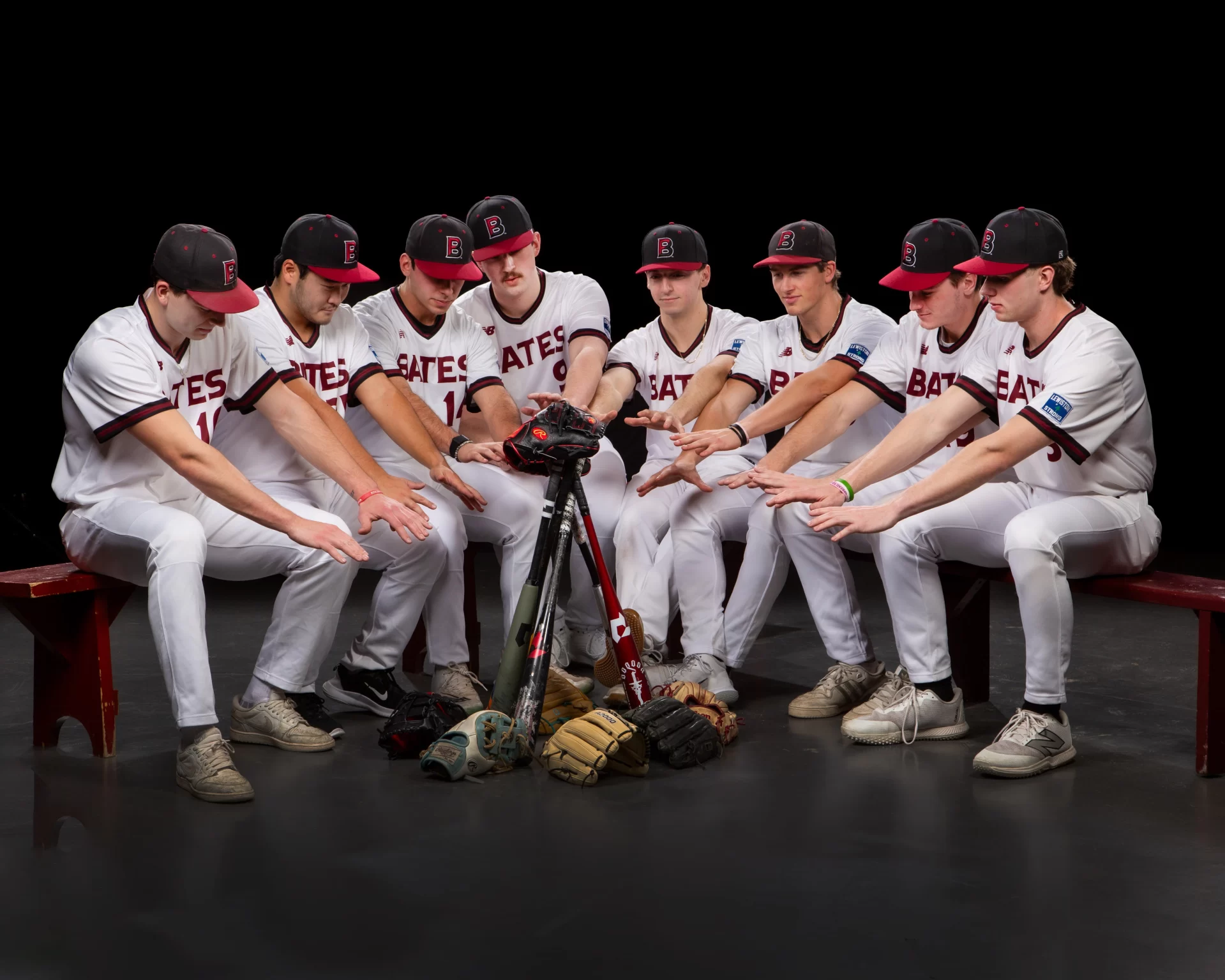 eight baseball players pretending to sit around a camp fire.