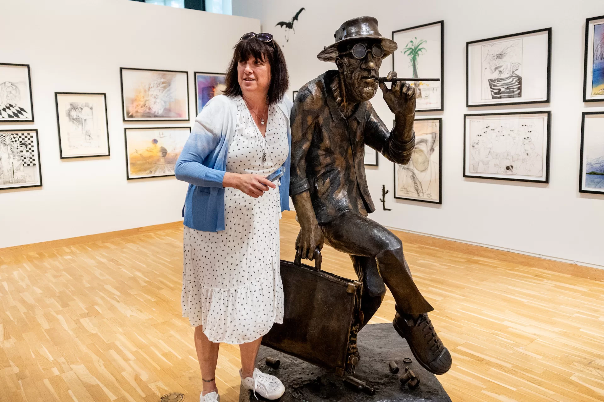 Sadie Williams, Ralph Steadman’s daughter and the managing director of the Ralph Steadman Art Collection, circulates on in the main gallery where an exhibition of her father’s work, “Ralph Steadman: And Another Thing,” opens tomorrow, June 6, 2025, and runs through Oct. 11, 2025, in the Bates Museum of Art.
This extensive traveling exhibition spans over 60 years of Ralph Steadman’s influential and lauded career, and features more than 140 original artworks and ephemera, including sketchbooks, handwritten notes, and personal photographs. Visitors to the exhibition will encounter familiar favorites, like the artist’s illustrations for literary classics such as Lewis Carroll’s Alice in Wonderland and Robert Louis Stevenson’s Treasure Island, as well as works for activist causes, branding iconography, and even a life-sized bronze sculpture.