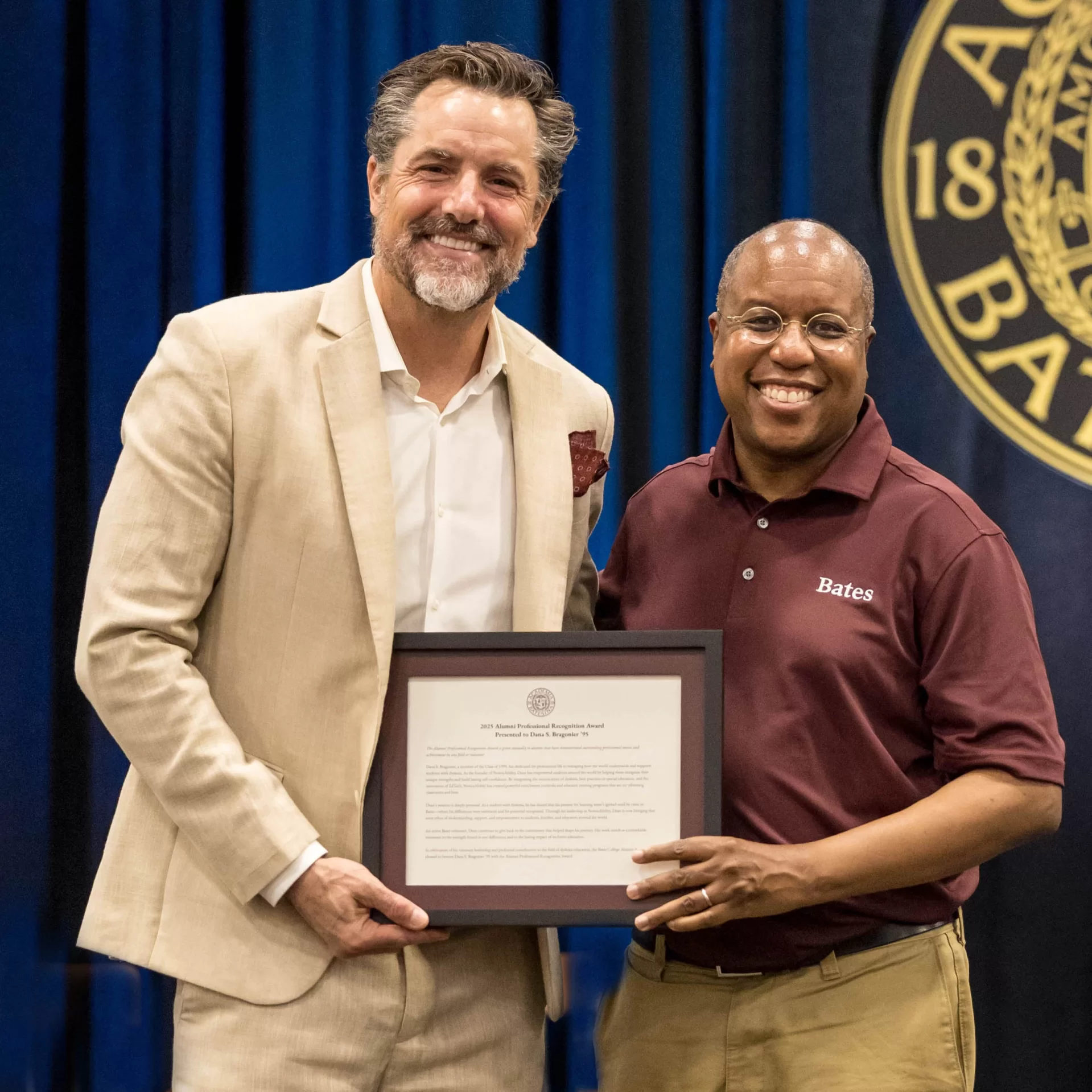 award winner posing with plaque and Bates President