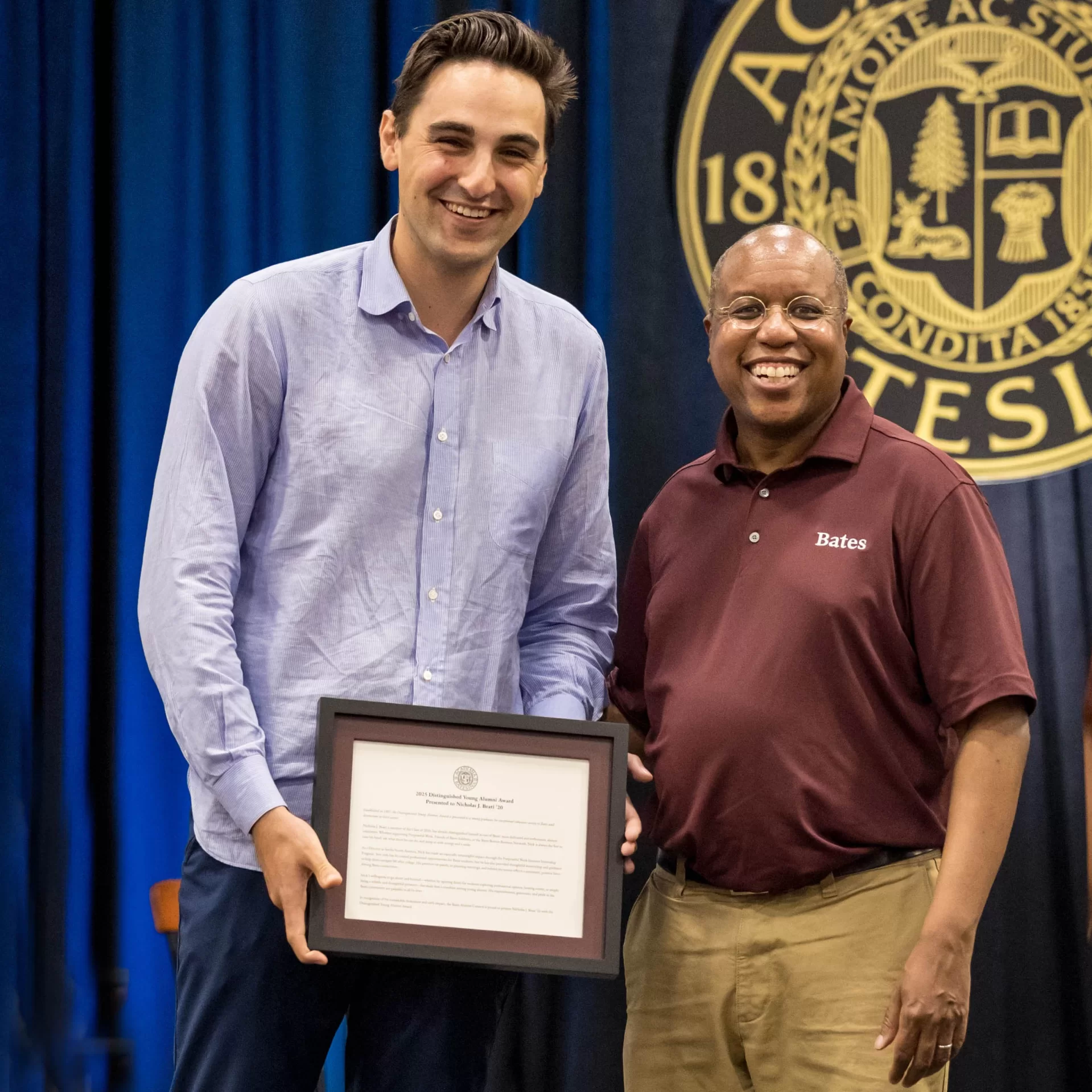 award winner posing with plaque and Bates President