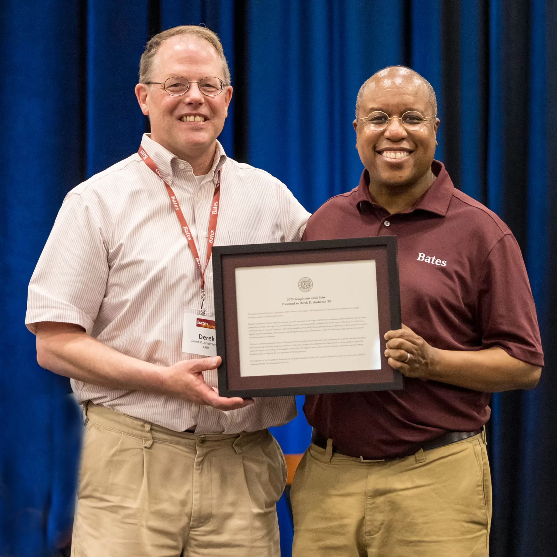award winner posing with plaque and Bates President
