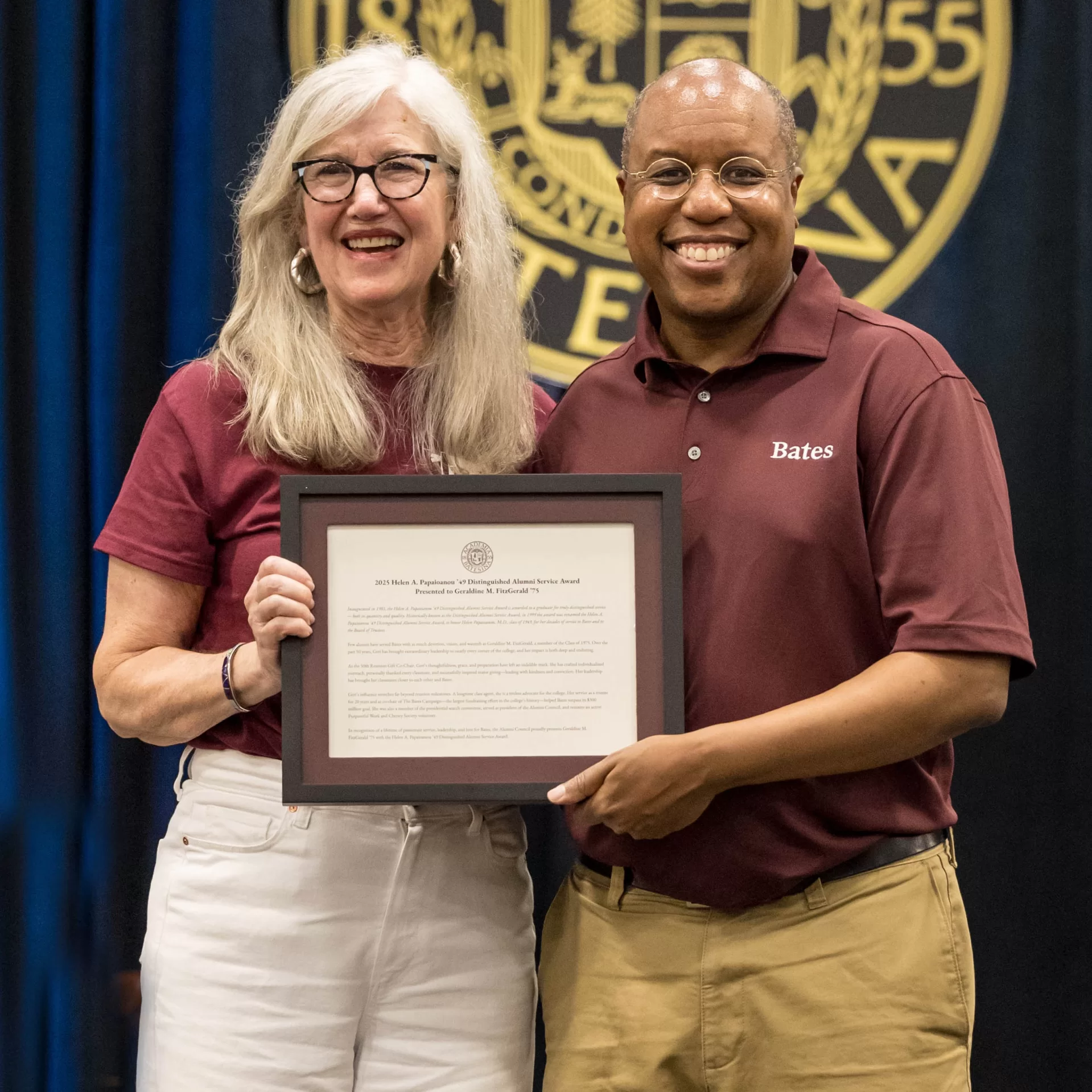award winner posing with plaque and Bates President