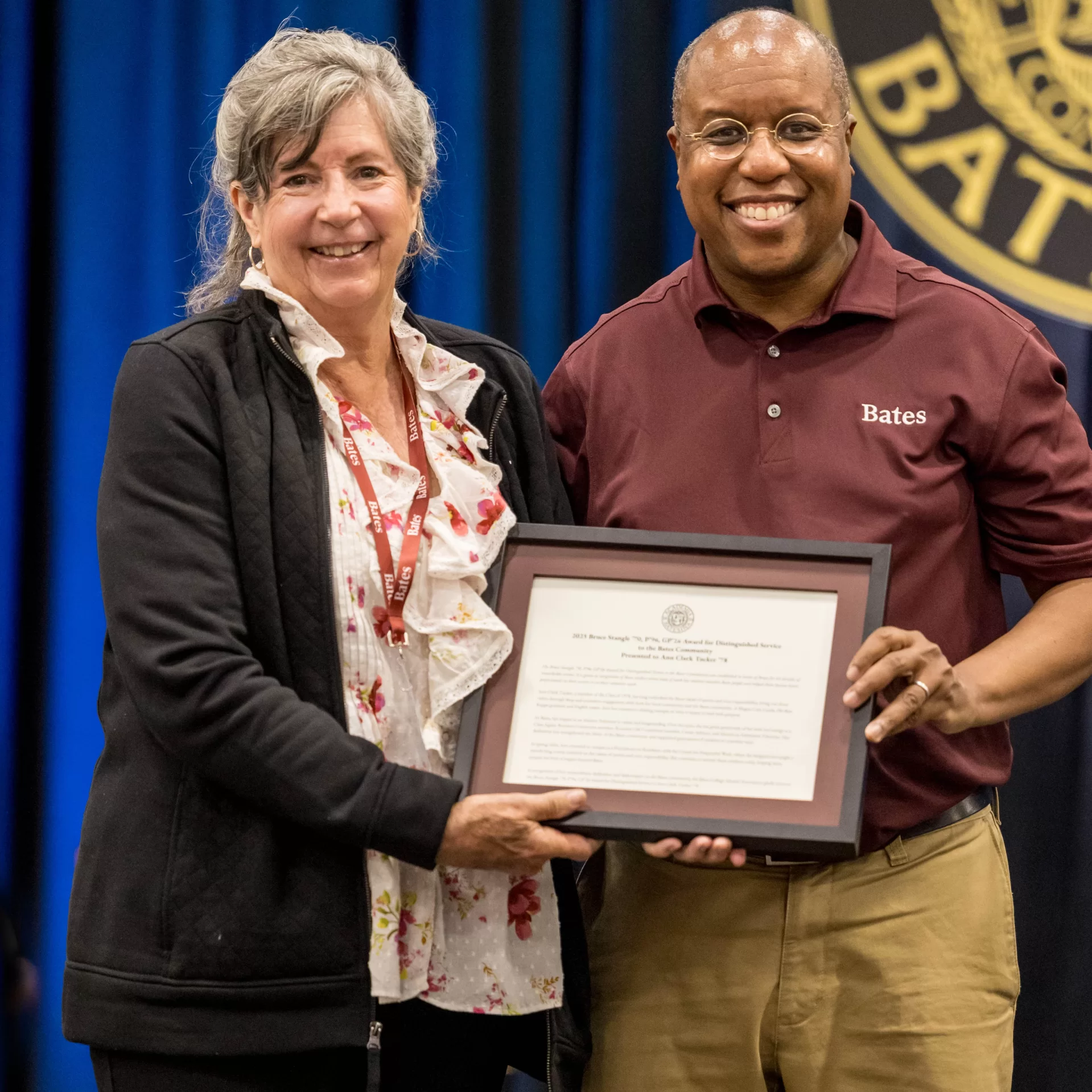 award winner posing with plaque and Bates President
