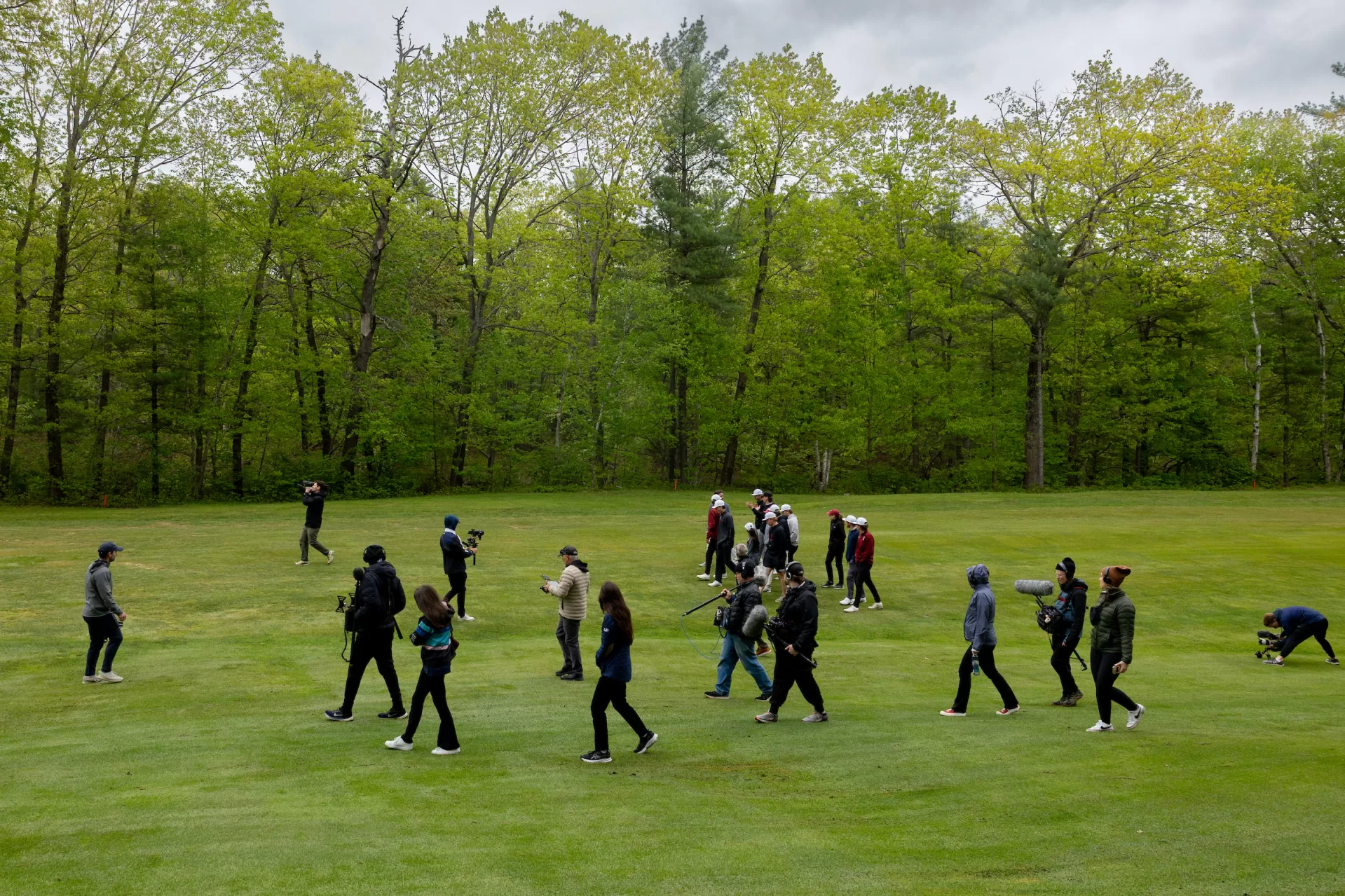 Surrounded by the film production team, the Bates golfers walk and talk with Derek Duncan, Golf Digest’s architecture editor, along the par-5 12th fairway at Martindale Country Club in Auburn, Maine, on May 20, 2025. (Phyllis Graber Jensen/Bates College)
