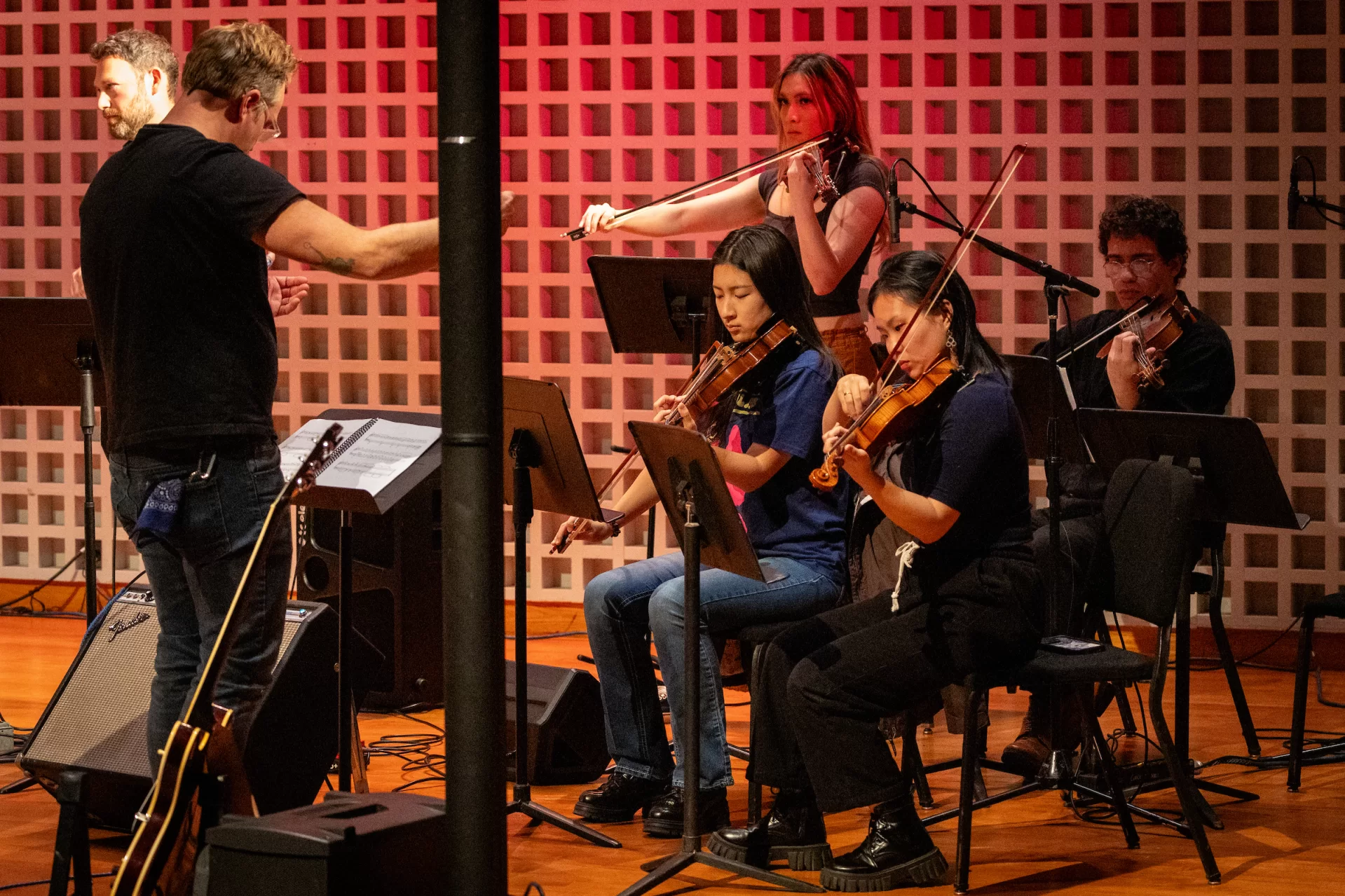 Stuart Gurley, who manages both Olin Arts and the applied music program at Bates, conducts several Bates students as they play alongside Fitter Hapoier, a Portland-based Radiohead tribute group, at the Olin Arts Center October 25. Standing at the back is Mavy Ho-Le ’26 of Gorham, Maine and front, from left are violinists Kelly Li ’27 of China and Xucheng Zheng ’27 of Shanghai, China 2025. (Sammy Weidenthal ’27 for Bates College)