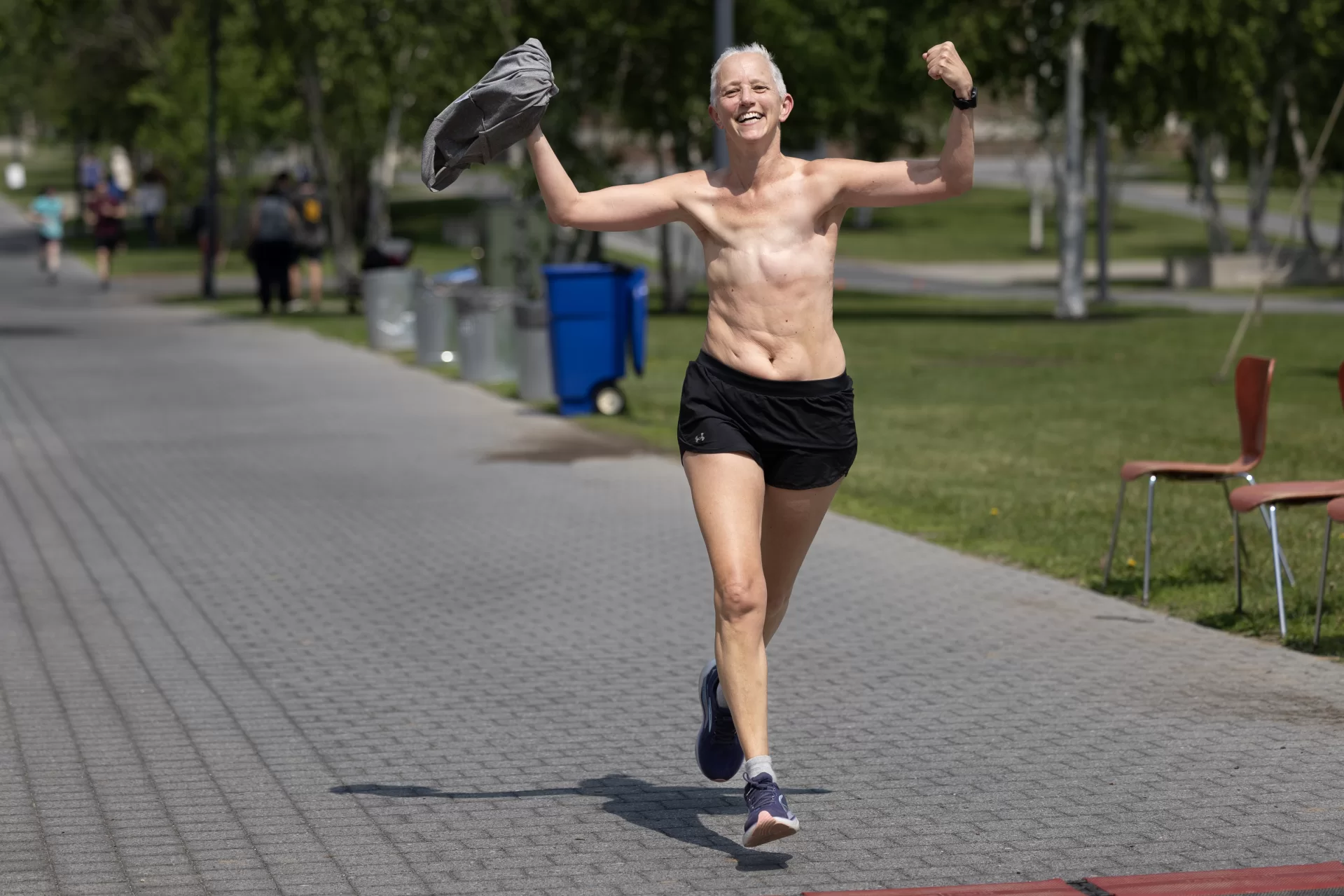 This year was no different. It was a beautiful Maine summer day for the annual Bates BWell 5K run and walk, where more than 200 Bates faculty and staff — including @presgarryjenkins and his lightning-fast husband @jonleelawprof — came out to make their way through a winding course that touched all parts of campus and ended with the long home stretch — about the length of a modern aircraft carrier — on Alumni Walk.

And while approaching the finish of the BWell 5K is a positive and joyful moment for many who participate, it was especially meaningful for Associate Professor of Sociology Heidi Taylor, who triumphantly removed her shirt revealing her double mastectomy shortly before crossing the finish line. It’s a practice some breast cancer survivors use to normalize mastectomy to show the positive sides of healing.

An avid runner, Taylor was treated for breast cancer in 2021 and had to cancel many of her races in order to schedule various treatments and surgeries. But there was a short window between surgeries when she could fit in one race — and that just happened to be the 2021 Bates BWell 5K.

“It meant so much to me. I was sort of nervous about it, and my friend [Associate Professor of History] Joe Hall met me and he raced to the end of it with me. And it just felt so victorious,” said Taylor.

And on this year’s t-shirt “celebration”?

“Last year I thought I would whip my shirt off and then I didn’t. But this year… I’m like ‘Just do it.’ So I think it’s good for awareness.”

At the BWell 5K, it’s not just about the finish line — it’s about who runs (and walks) beside you.