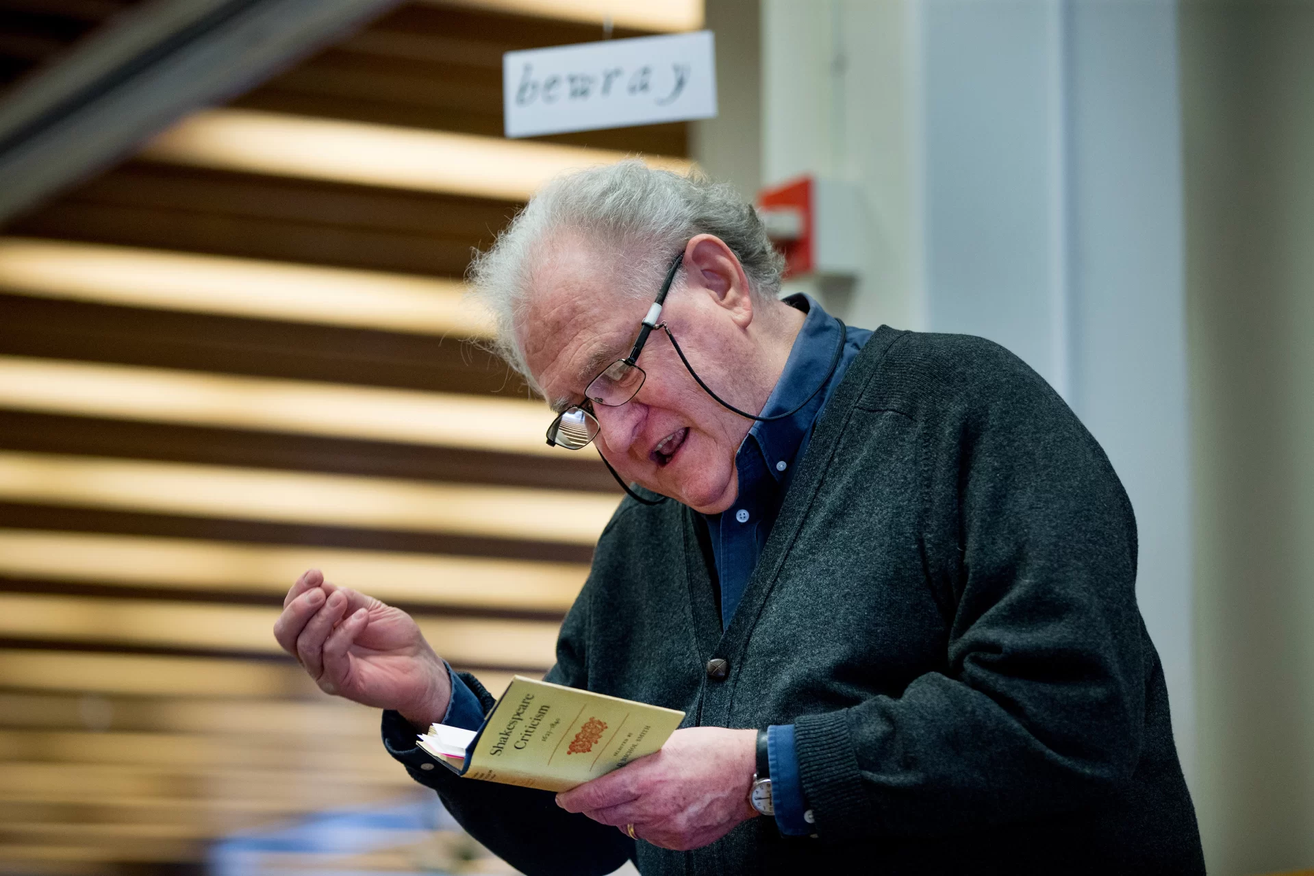 A man reads out loud from a book.