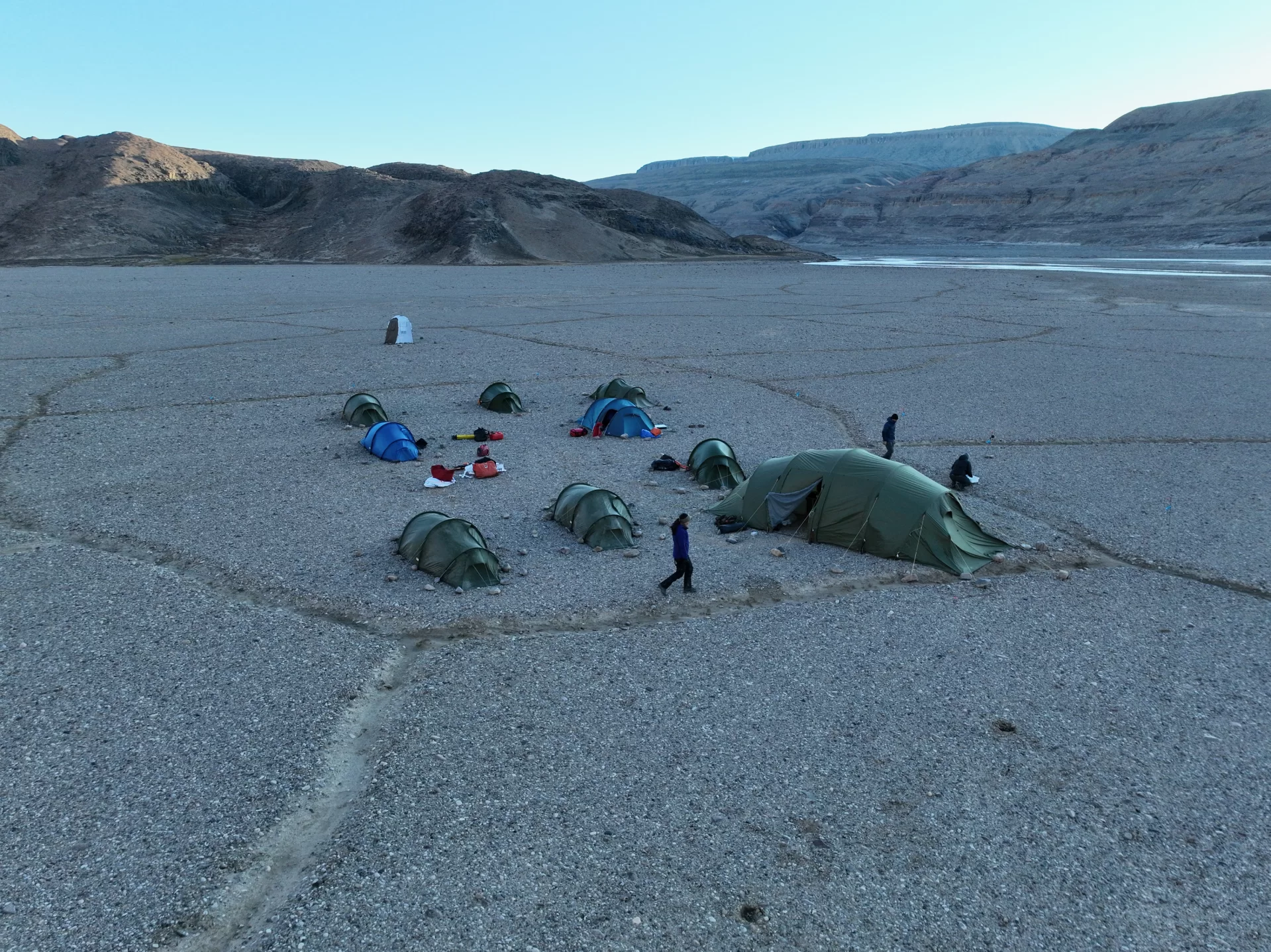 A measuring tape is set between two long sediment samples in tubes.