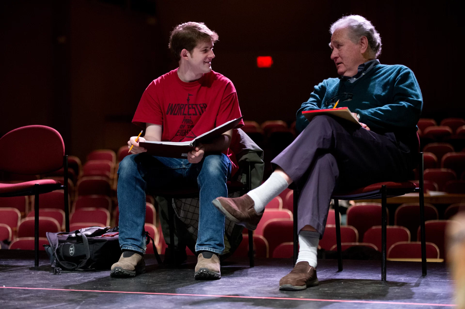 Two men read lines onstage.