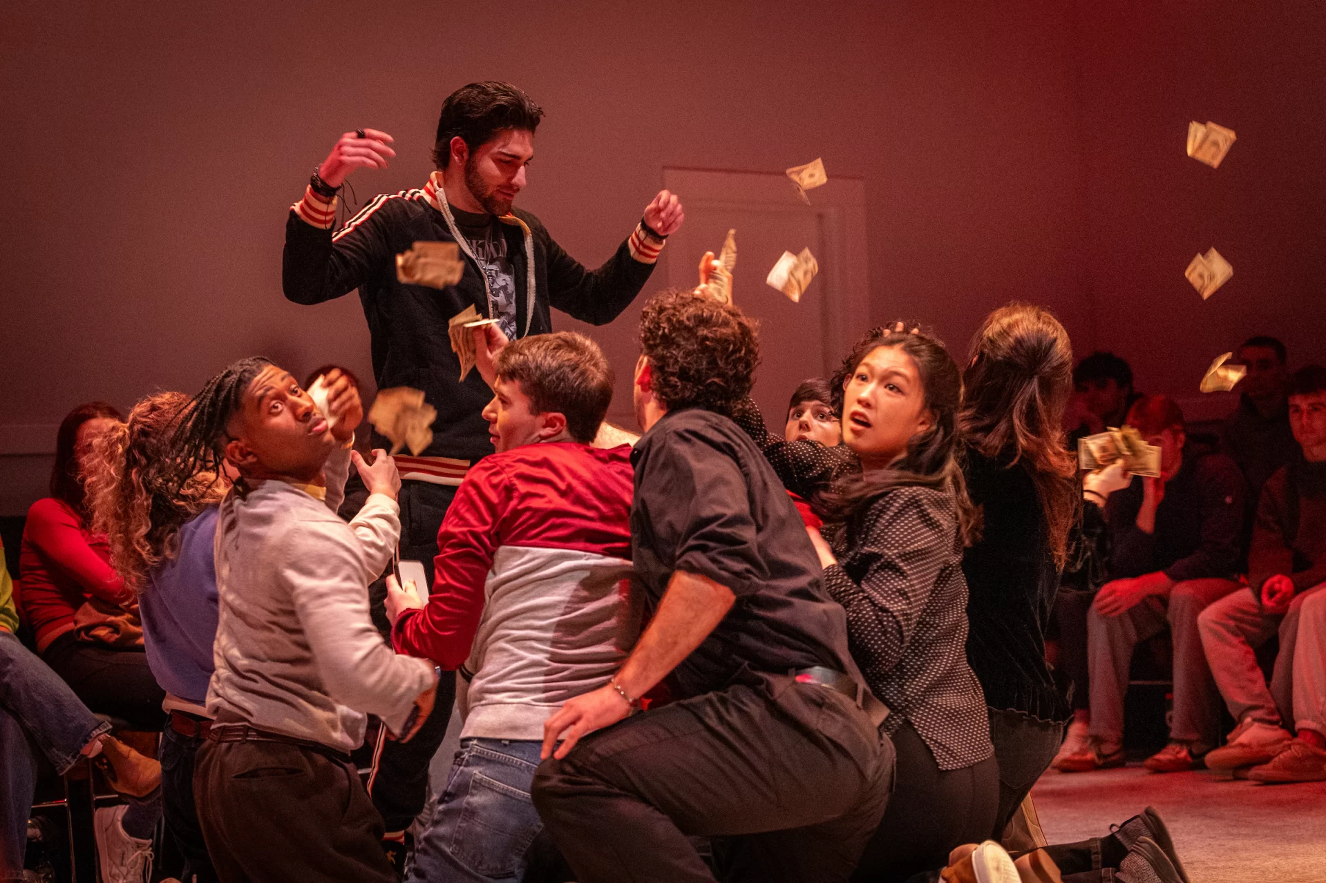 A group of people through pieces of paper around on a stage.