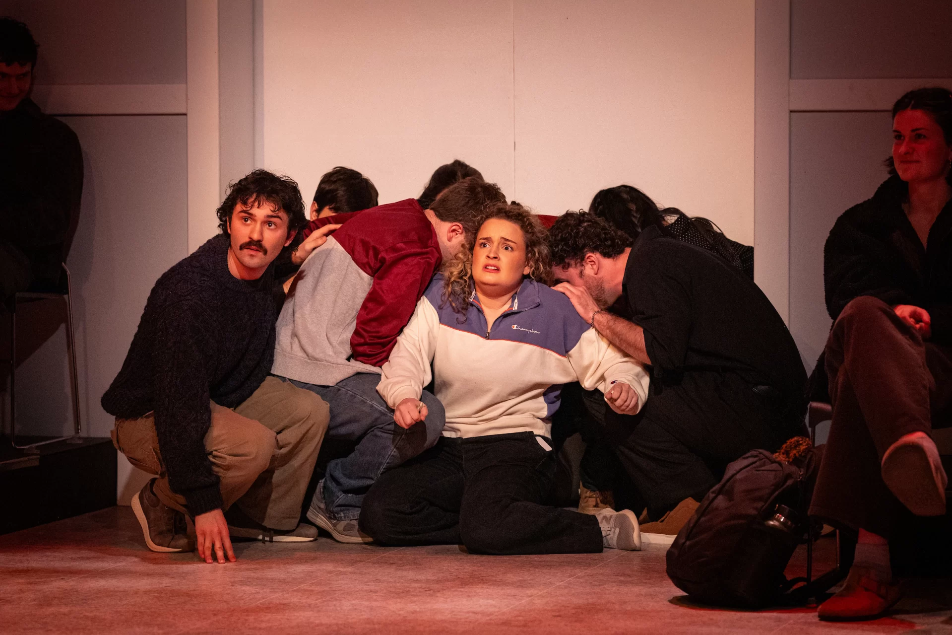 A group of people pose dramatically on a stage.