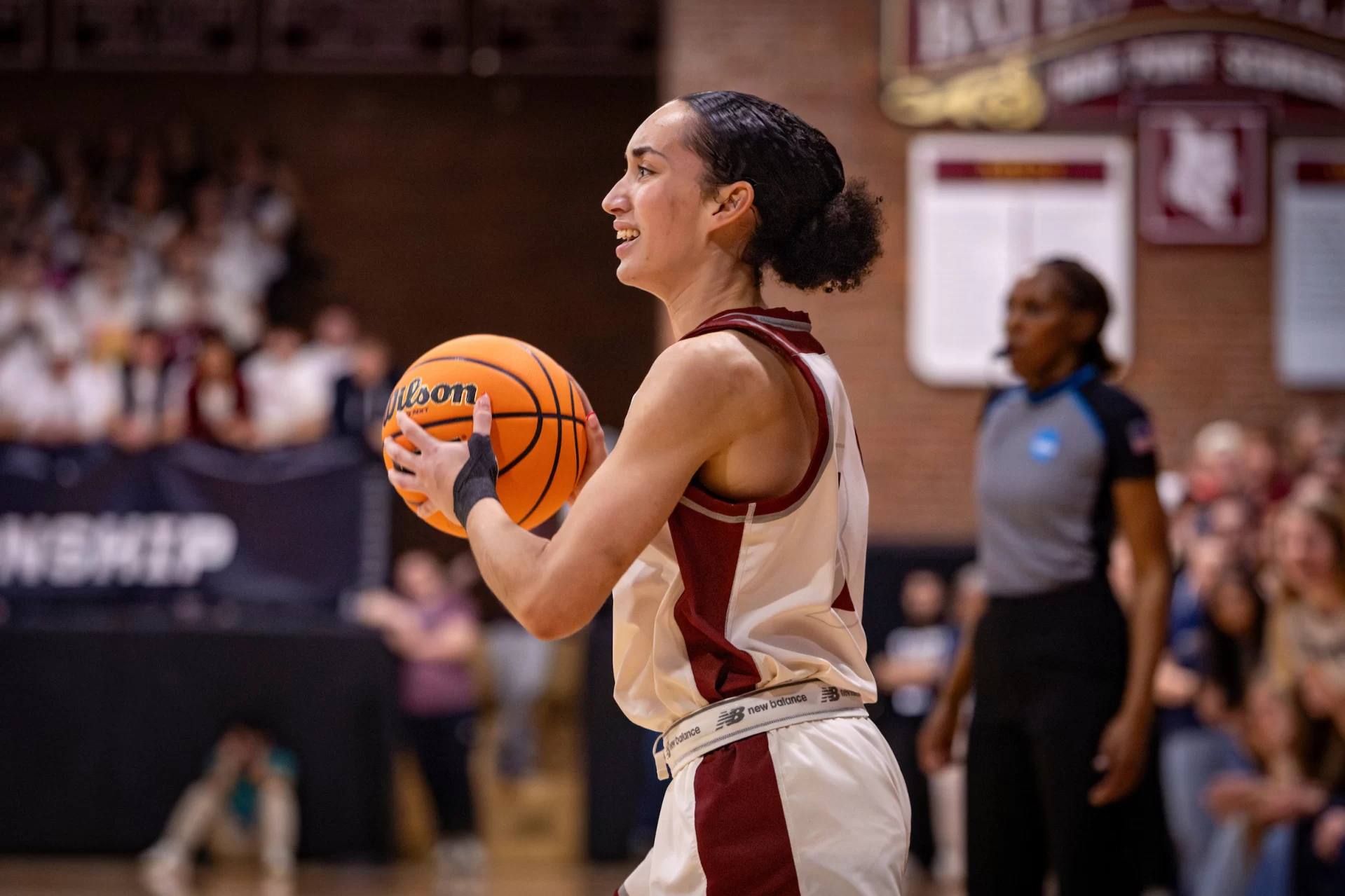 A women's basketball player prepares to shoot a basketball into a basket.