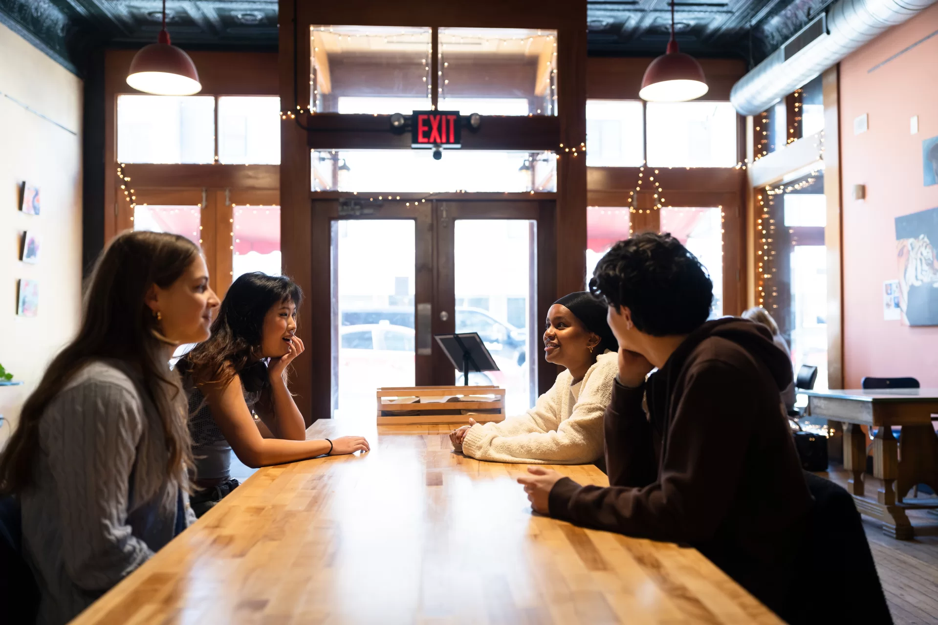 Lewiston, ME, United States -- Bates College students, clockwise from back left, Misra Ahmed, Paolo Lopez, Phoebe Last, and Cathy Shi share a meal and drinks at Forage Market in Lewiston, ME on Wednesday, March 25, 2026. (Photo by Yoon S. Byun) © 2026 Strewn Wonder, LLC