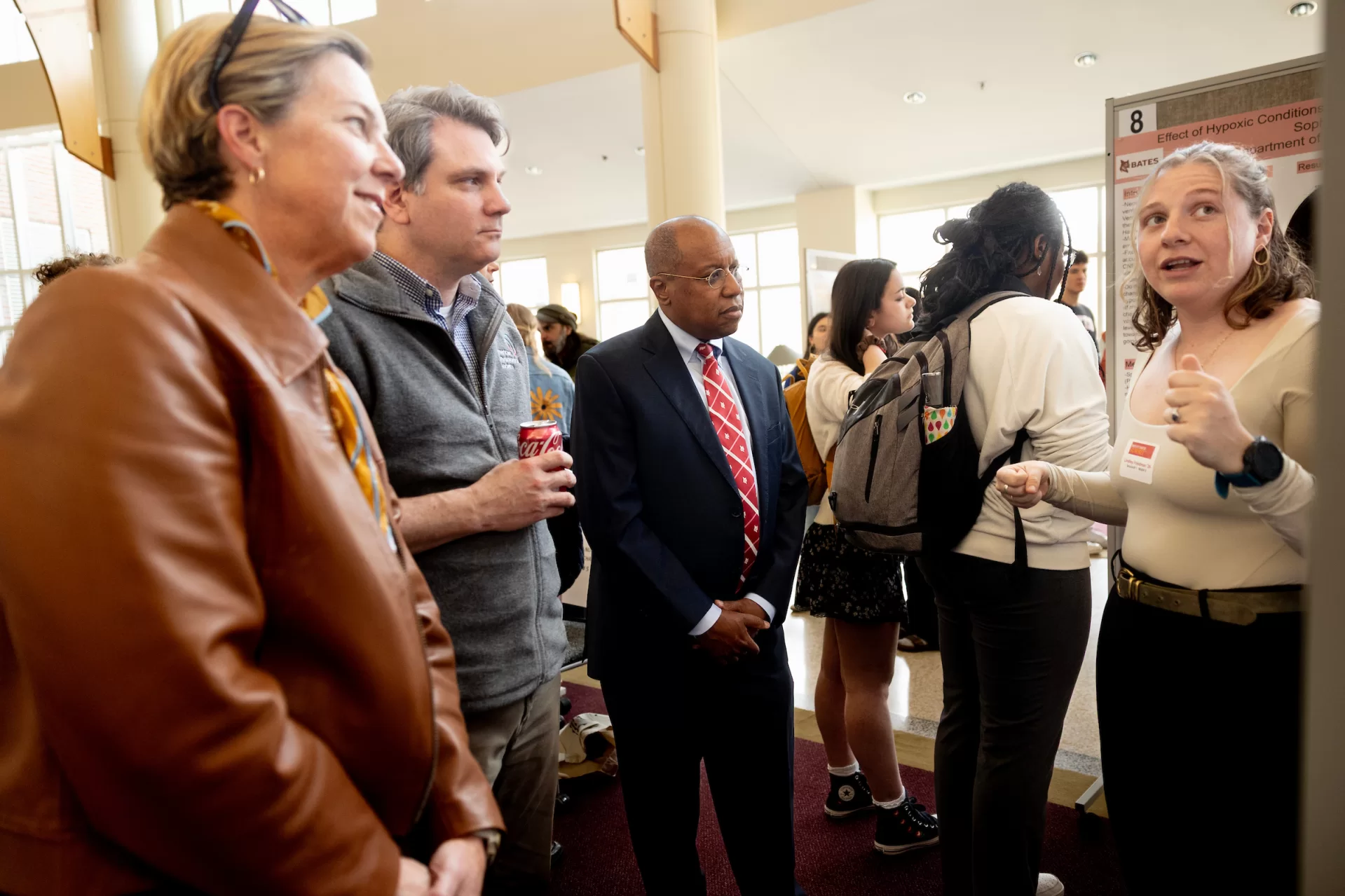 A woman presenting a poster to a group of people.
