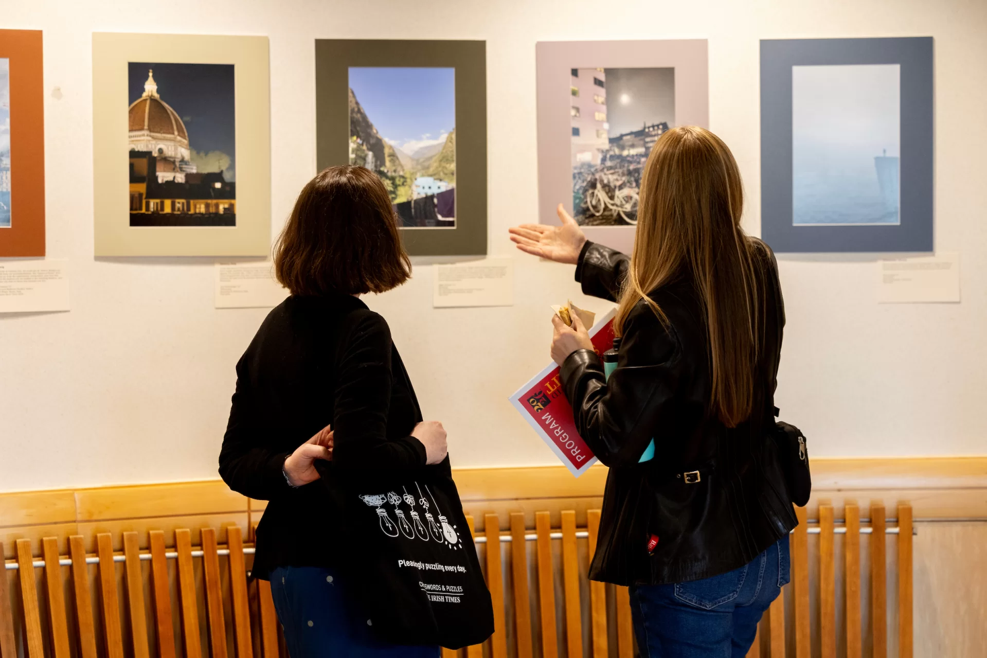 Two people looking at displayed photographs.