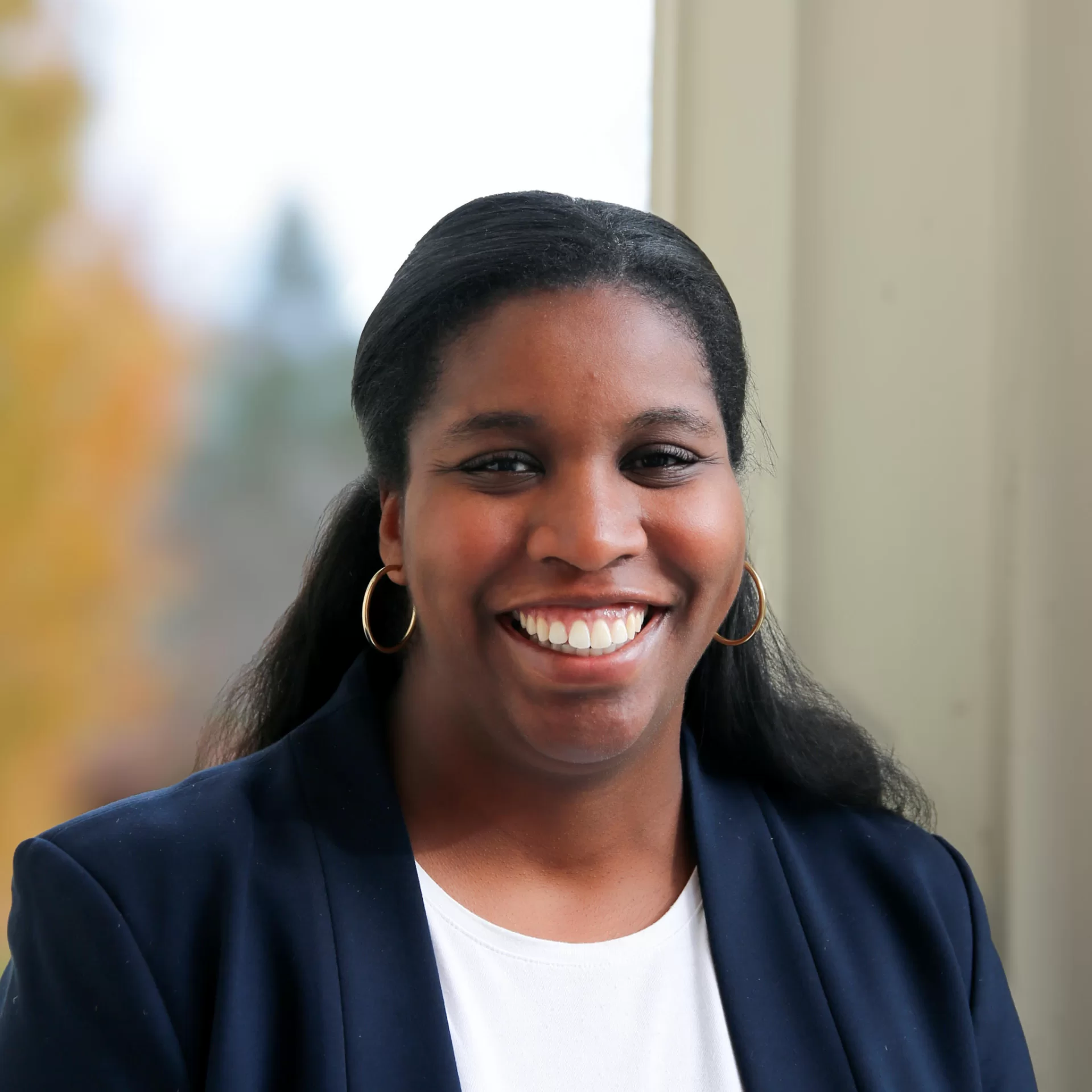 A headshot of a woman standing outside.