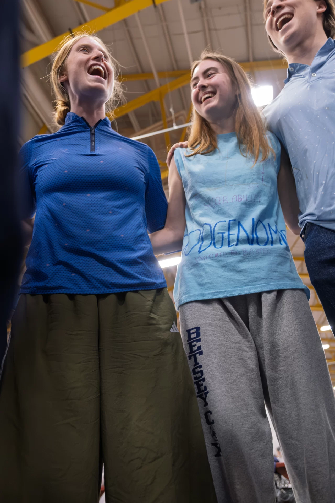 Three people huddled together on a court.
