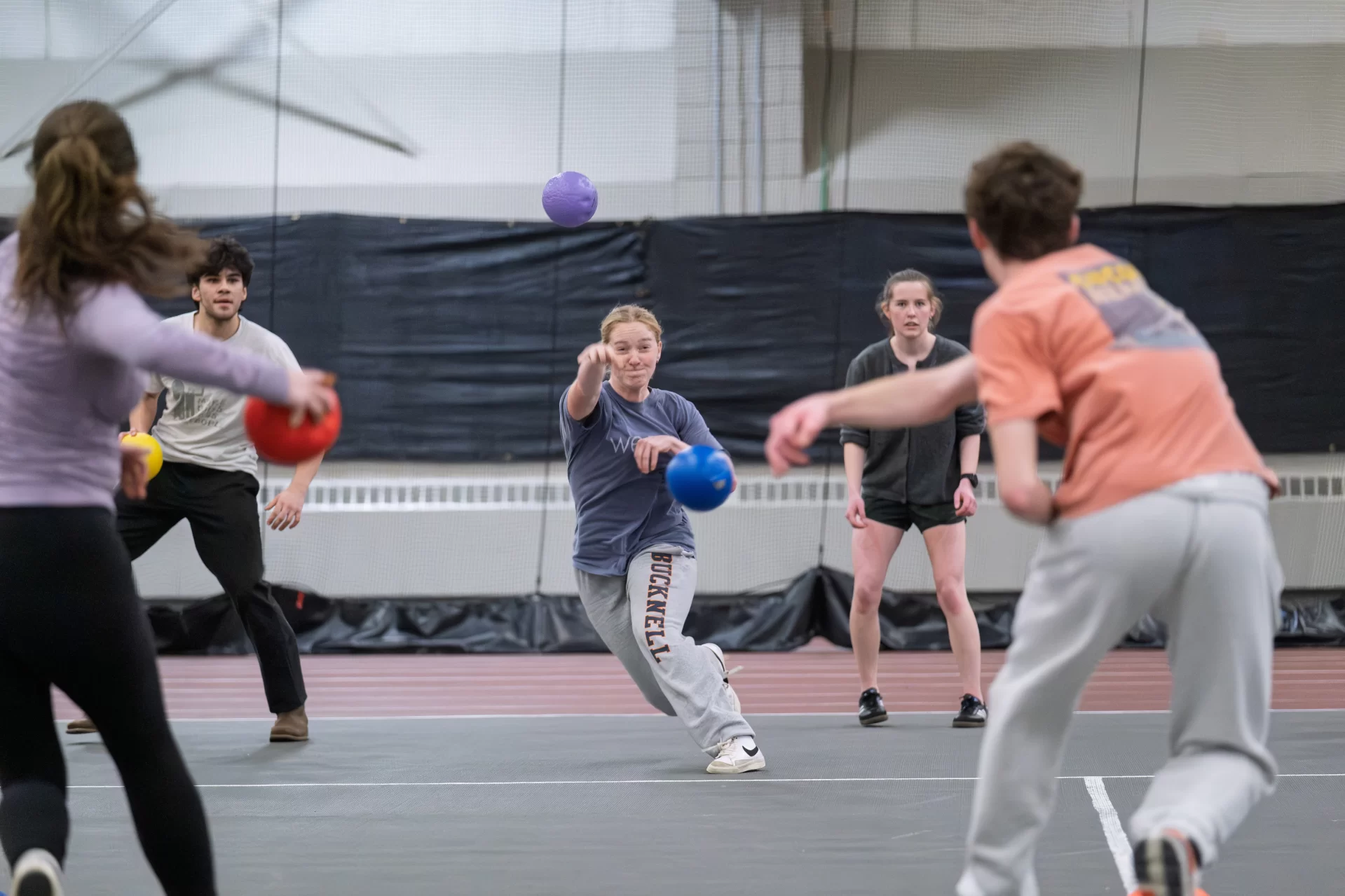 A group of student throwing balls on a court.