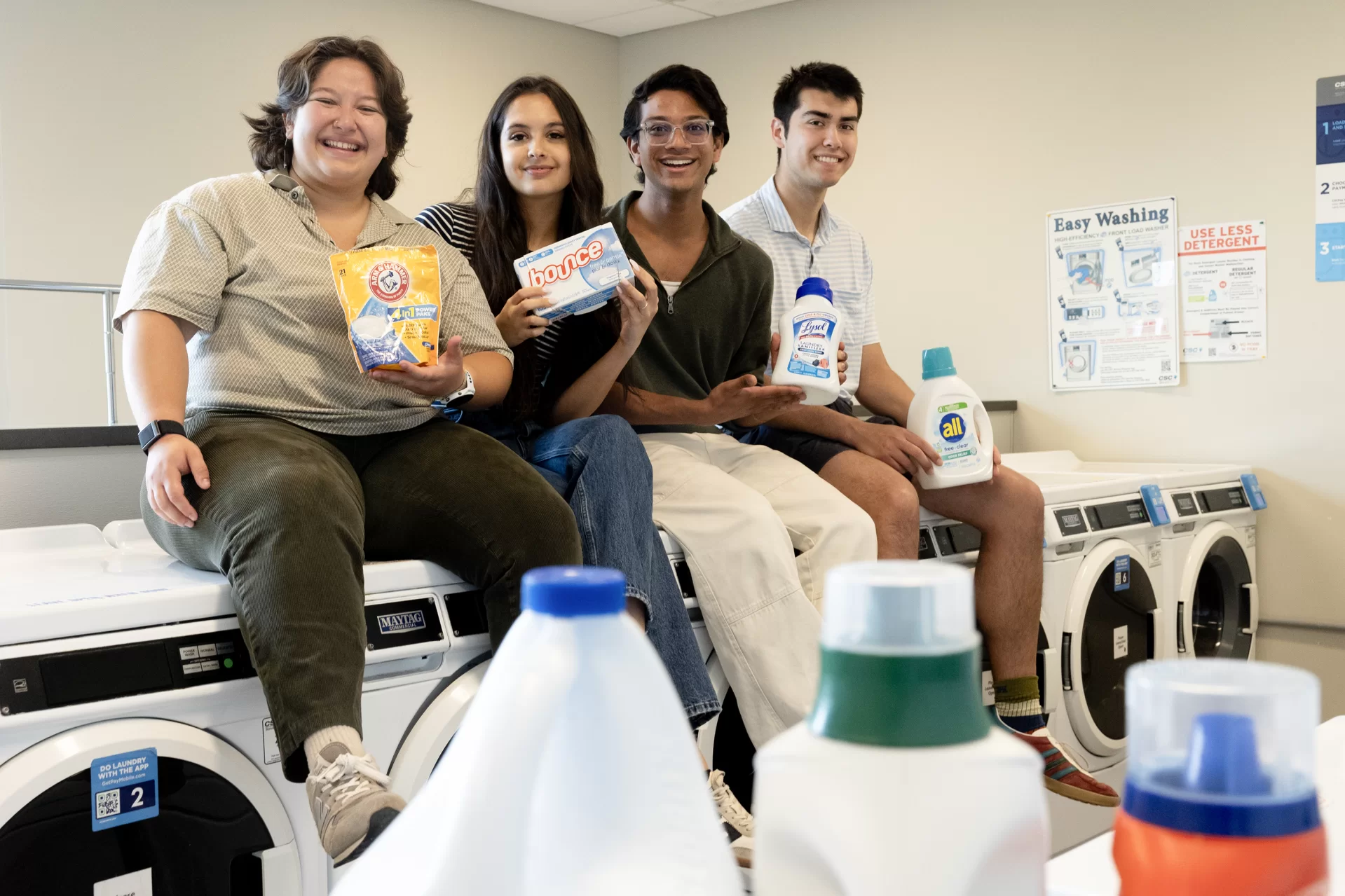 Students who were involved in securing free laundry washing for all Bates students, posing in the laundry room in Chu Hall on May 27, 2026. Aleisha Martinez Sandoval ’26 of Mexico City, Trinity Monstwillo ’26 of Corvallis, Ore., Mohammad Zayd ;27 of the Bronx, N.Y., and Zachariah Richards ’26 of Princeton, Mass.