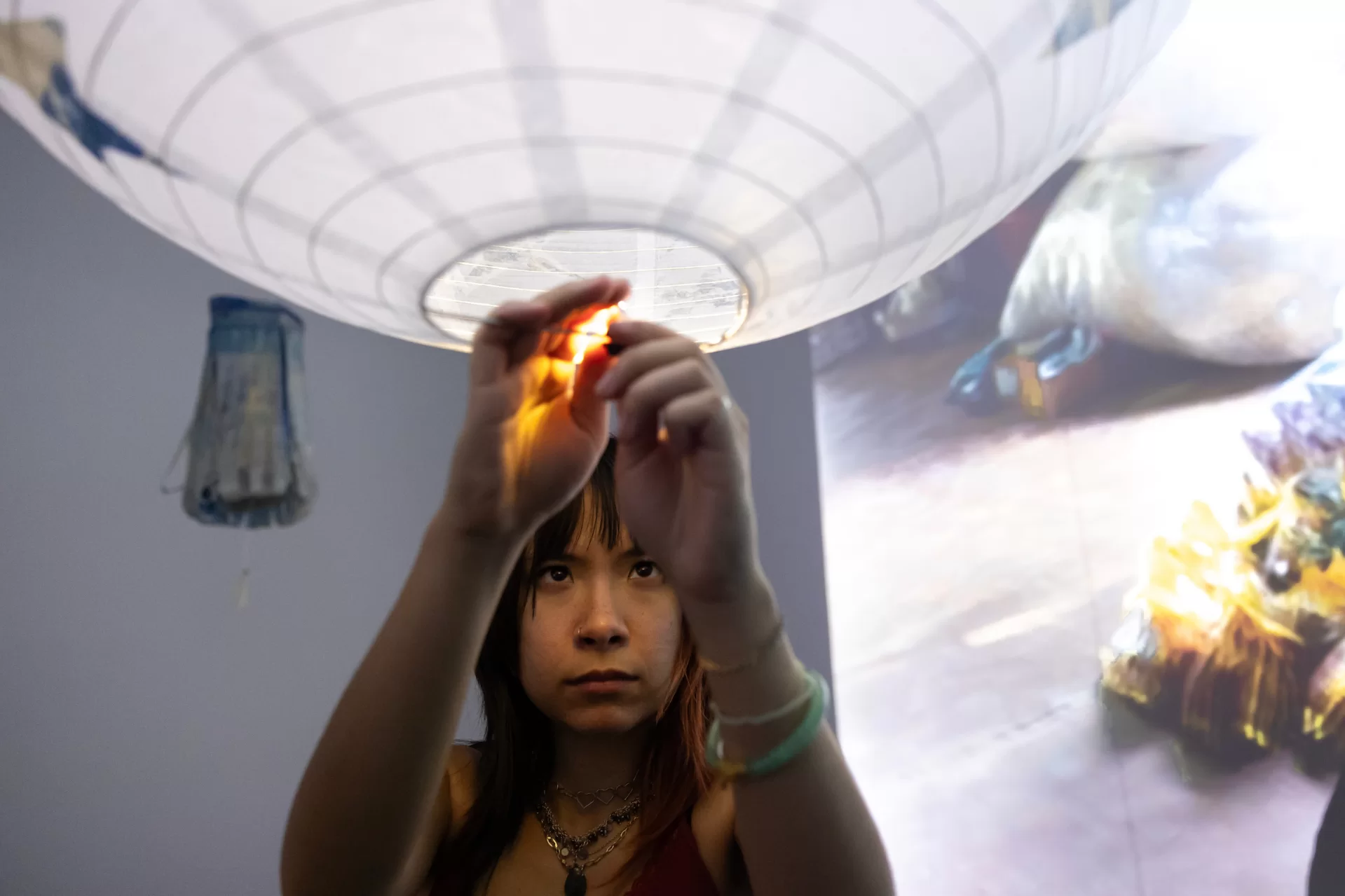 A woman putting a light inside a lantern cover