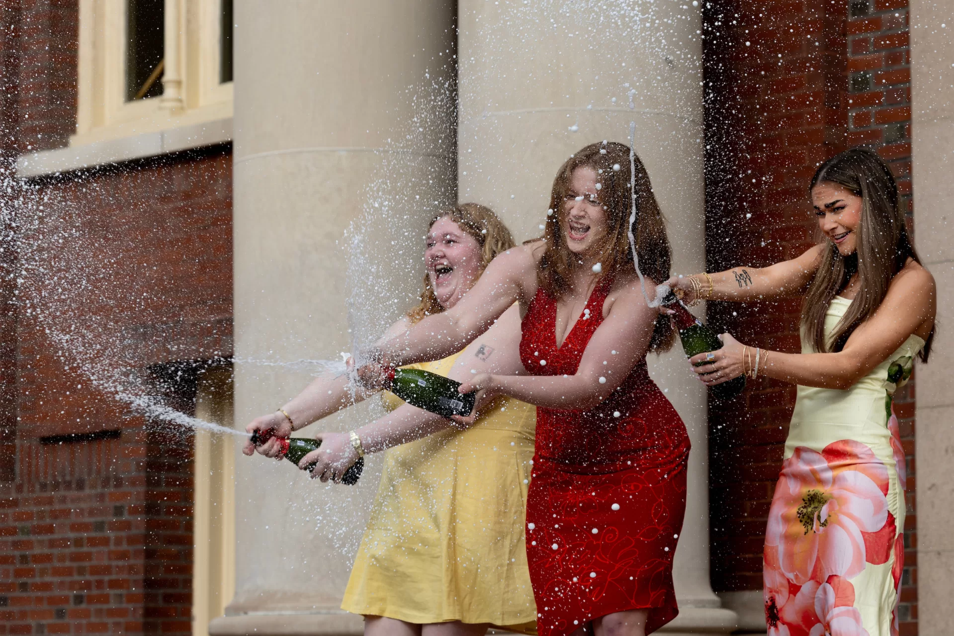 Three best friends bind their theses on the steps of Coram Library on May 12, 2026.

Some context is that Kayleigh and I were randomly assigned roommates our freshman year and have lived in a double for all 4 years. Lauren and Kayleigh met on AESOP and studied abroad together in Korea last year. All 3 of us have been best friends since the first week of freshman year. I attached a tik tok I made of the binding that captures our relationship. If the link doesn't work I also direct messaged it to the Bates instagram from the account username mallory.johnson


Lauren Cockrill (went first, red dress)
- Hometown: Huntersville, North Carolina
- Major: Biochemistry
- Career goal: physical therapist
- Thesis title: Blood, Sweat, & Tears: A Comprehensive Review on the Menstrual Cycle and its Relation to Diet, Exercise, and Recovery


Kayleigh Flaherty (went second, short yellow dress)
- Hometown: Litchfield, Maine
- Majors: East Asian Studies & Biology
- Career goal: physician's assistant
- Thesis titles: 
        Women's Bodies, Men's Medicine: The Complexity of Gender and Medical Authority in Traditional Chinese Medicine
         The Pain We Overlook: An Ethical and Holistic Examination of Ashoka as a Treatment for Dysmenorrhea and Women's Healthcare Inequality


Mallory Johnson (went third, long yellow dress)
- Hometown: Boulder, Colorado
- Major: sociology. Minor: spanish. Pre med
- Career goal: emergency medical doctor
- Thesis title: Immigrant Health Inequity in Colorado


2 quote options from Mallory (feel free to shorten): 


"Structural inequity is not an abstract concept from a textbook, it shapes lived realities. To immigrants across the United States: you are a vital part of our communities. You are seen, valued, and deserving of dignity, safety, and human rights. My calling to medicine has expanded to a lifelong commitment to advocate for that. Your struggle is not a temporary news headline. Our solidarity is not a phase."


"I chose Bates for the sense of commu