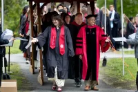 One Baccalaureate tradition is that the processional passes through archways adorned with prayers, poems, and blessings offered by parents, guardians, and other loved ones. Here the processional, led by President Garry W. Jenkins, makes its way through the Class of 2026 archway on May 30, 2026. (Phyllis Graber Jensen/Bates College) 