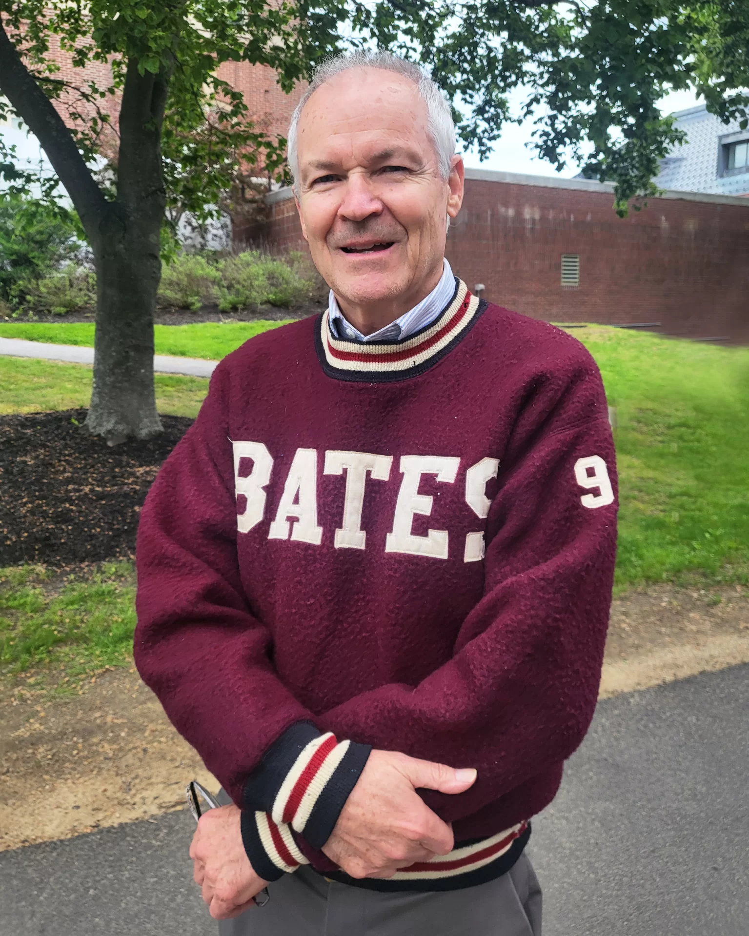 Peter Slovenski attended Commencement in a vintage Bates track warmup sweatshirt once worn by the outstanding Bates track athlete Rudy Smith ‘59. (Jay Burns/Bates College)