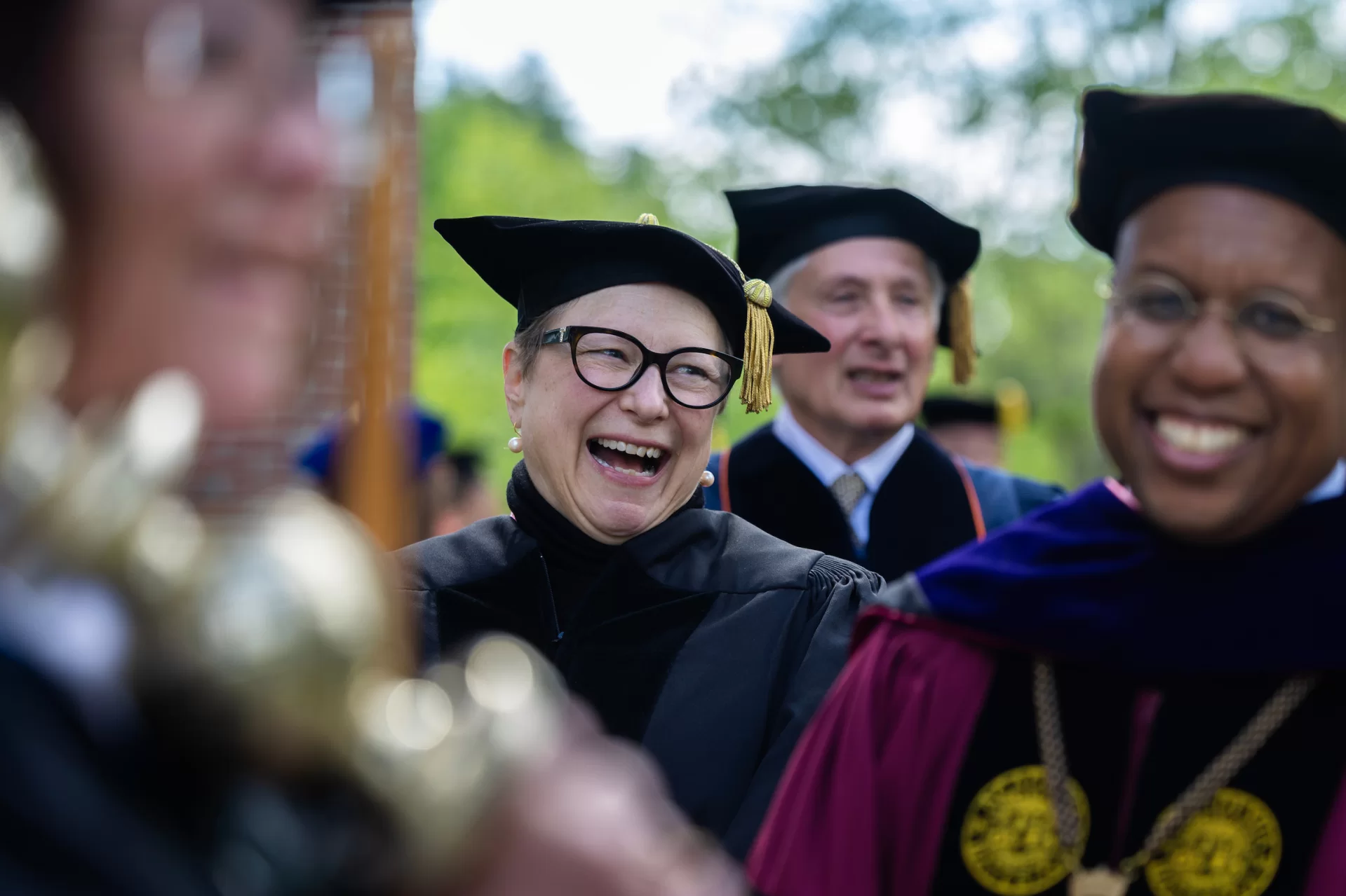 People smiling in graduation regalia