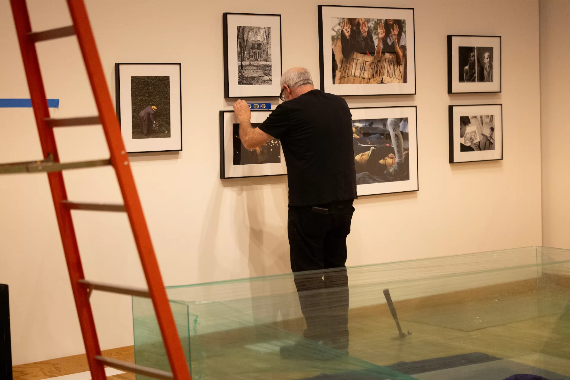 Kevin Callalhan works on getting everything just right for the opening of “Phyllis Graber Jensen: Picture Stories” at the Bates College Museum of Art. (Phyllis Graber Jensen | Bates College) 