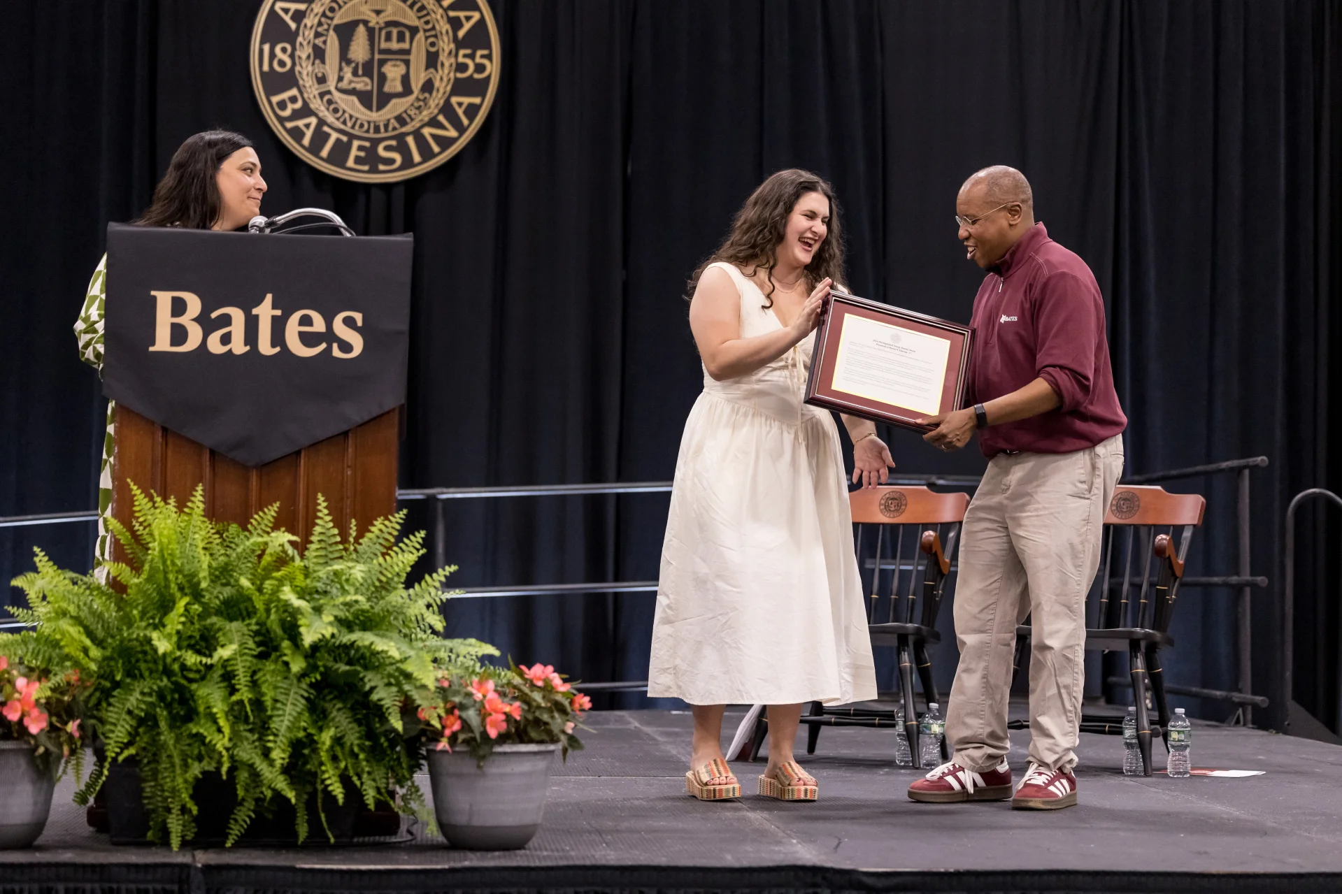 A man presenting an award to a woman on a stage